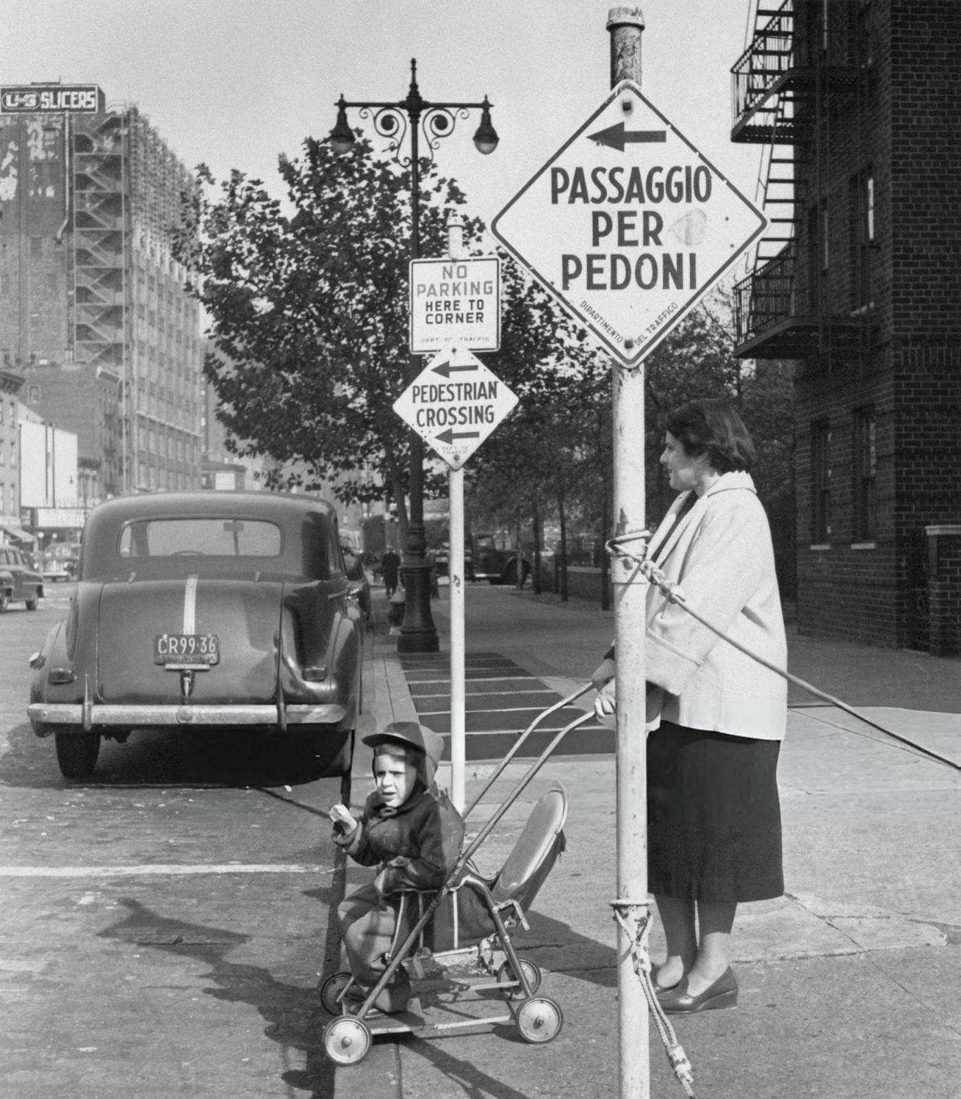 A woman waits to cross the road with a pushchair in Greenwich Village, 1954.