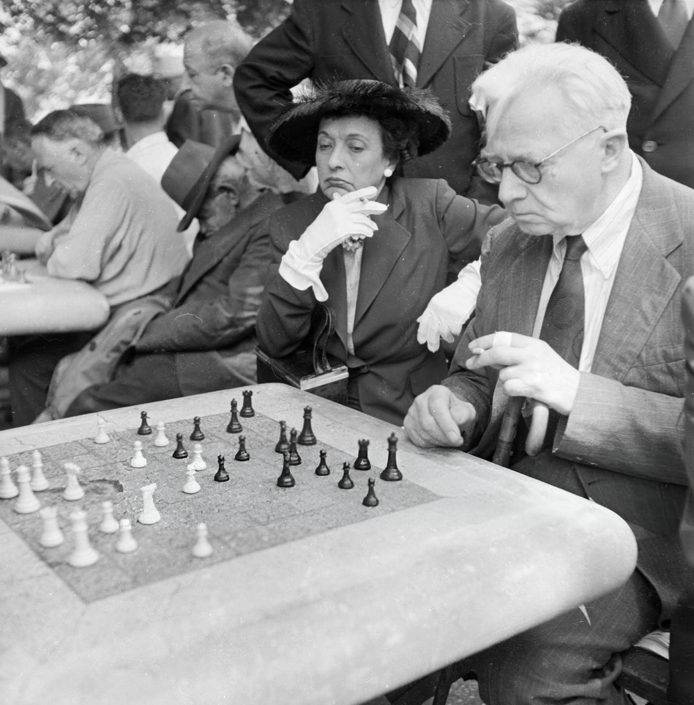 An elderly couple contemplates a chess game in Washington Square Park, 1955.