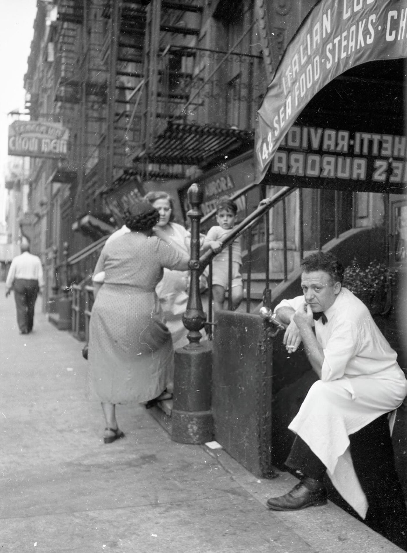 A waiter smoking outside an Italian restaurant in Washington Square Park, 1955.