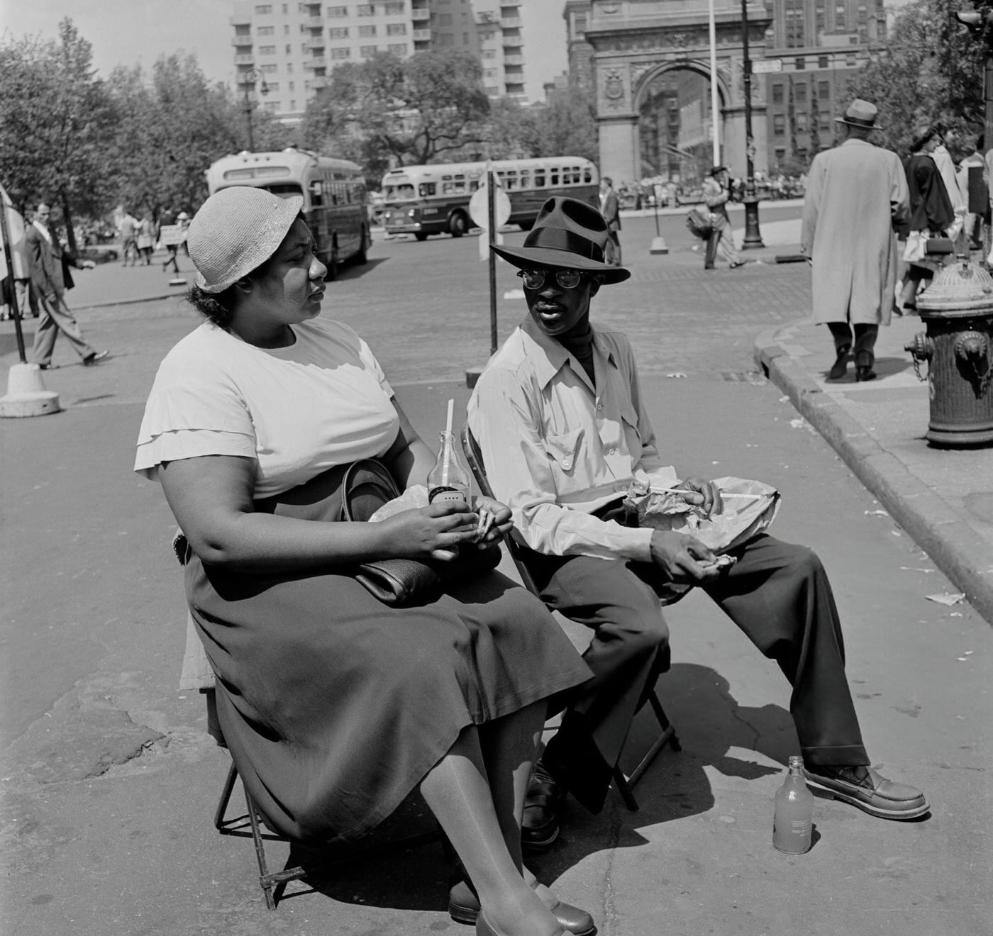 A man and a woman sitting in chairs near Washington Square Park, 1952.