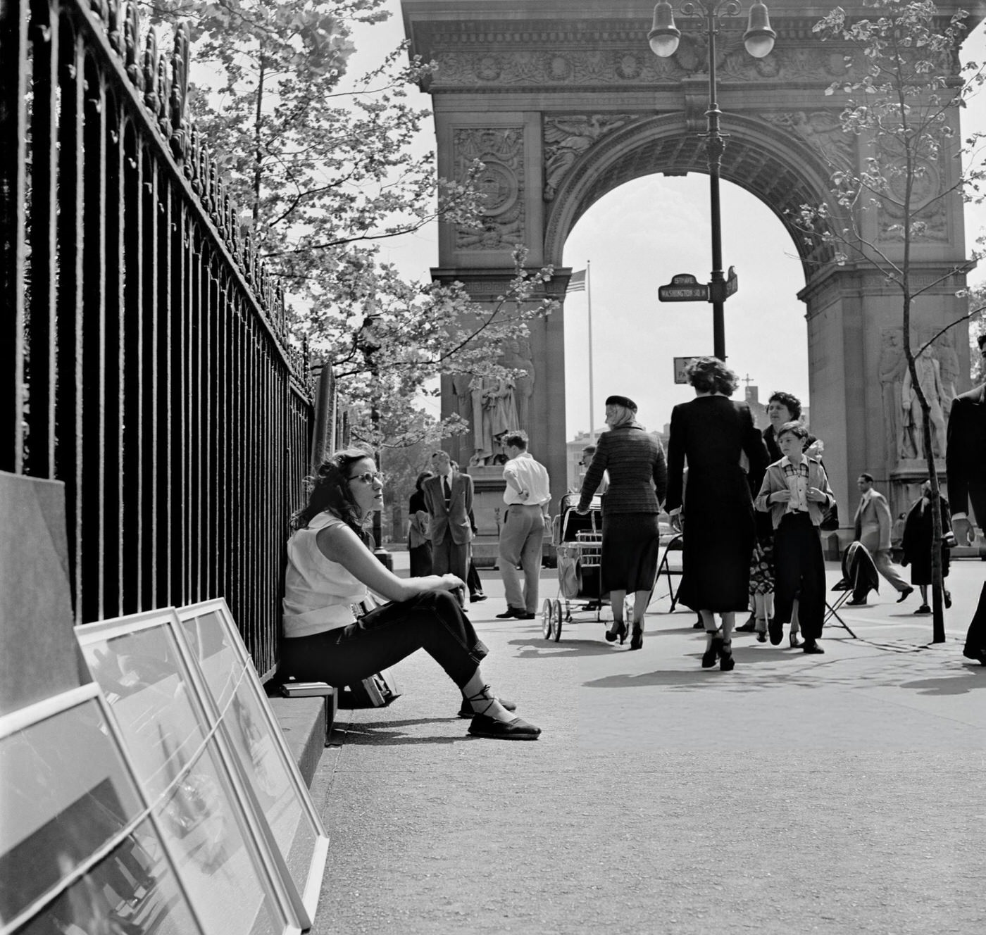 An artist sitting near her paintings in Washington Square Park, 1952.