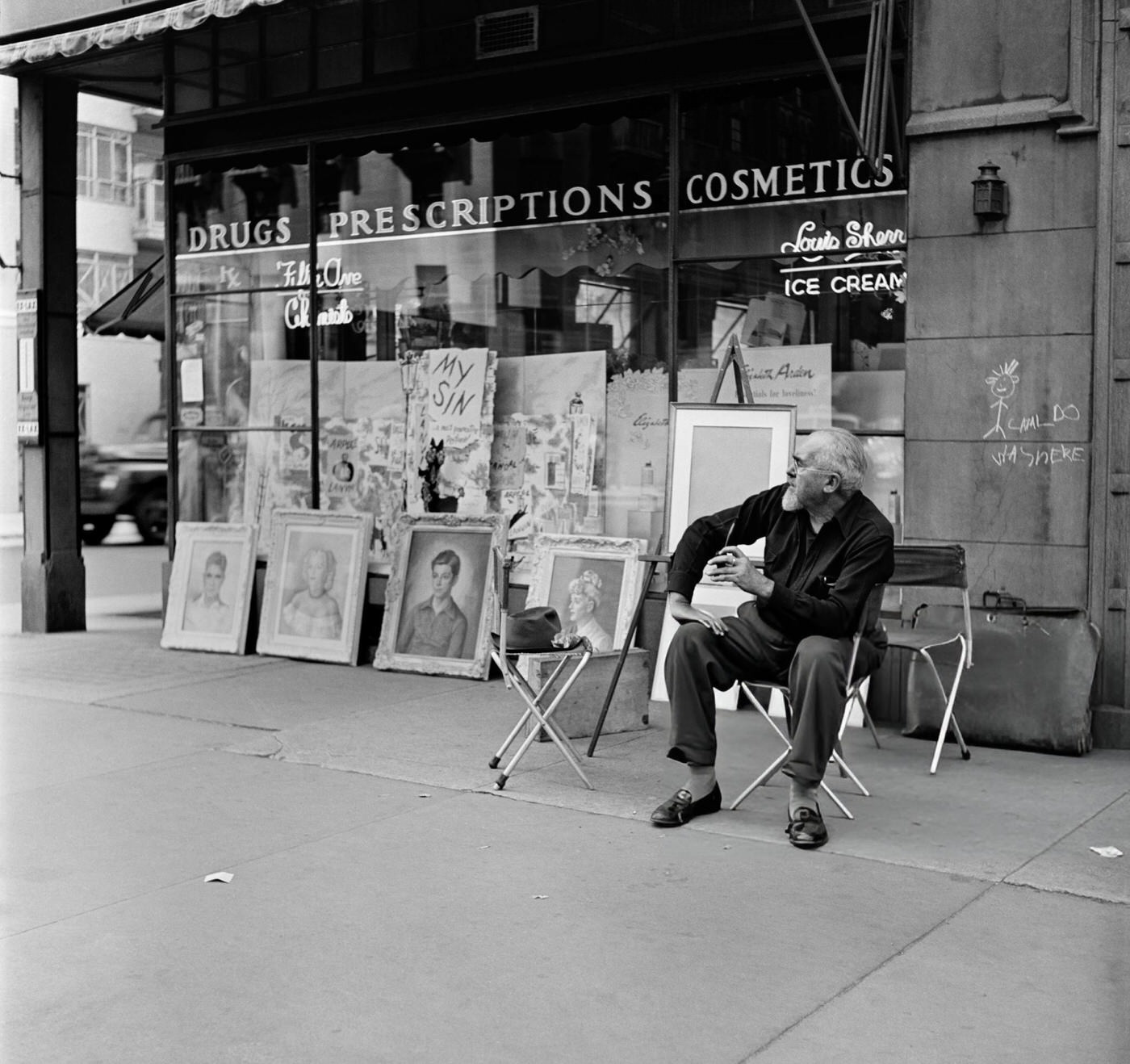 An artist exhibiting his paintings outside a drugstore in Washington Square, 1952.