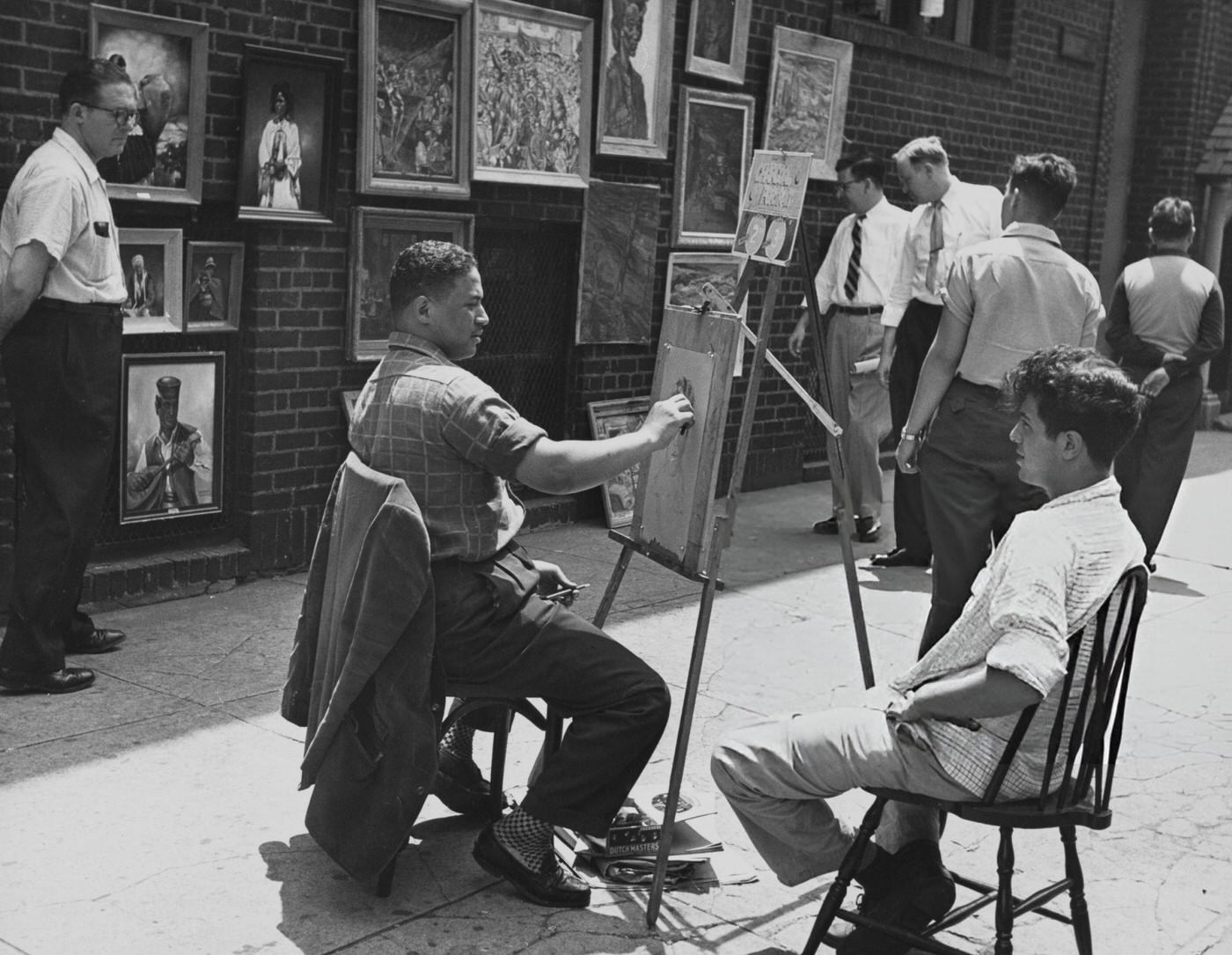 A Black artist drawing a portrait in Washington Square, 1955.