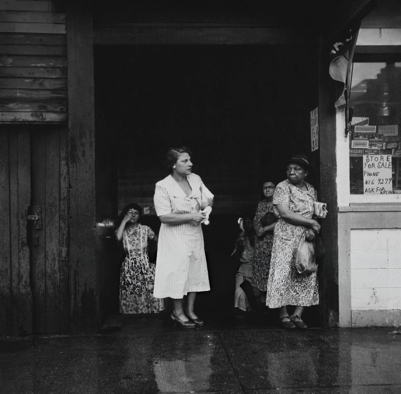 Women take shelter from the rain in Greenwich Village, 1955.