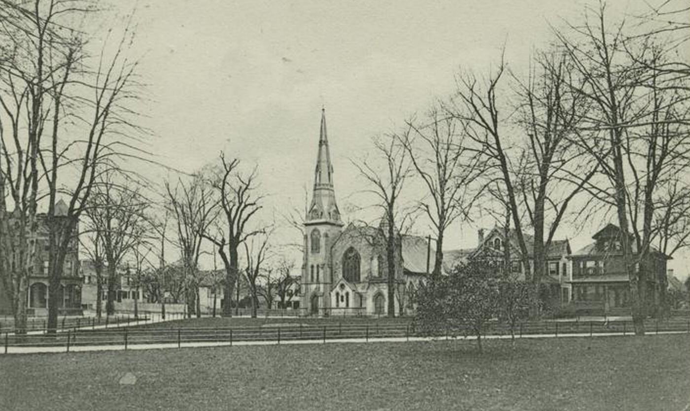 Public Park, Port Richmond, featuring a large church and houses on the street, 1900s.