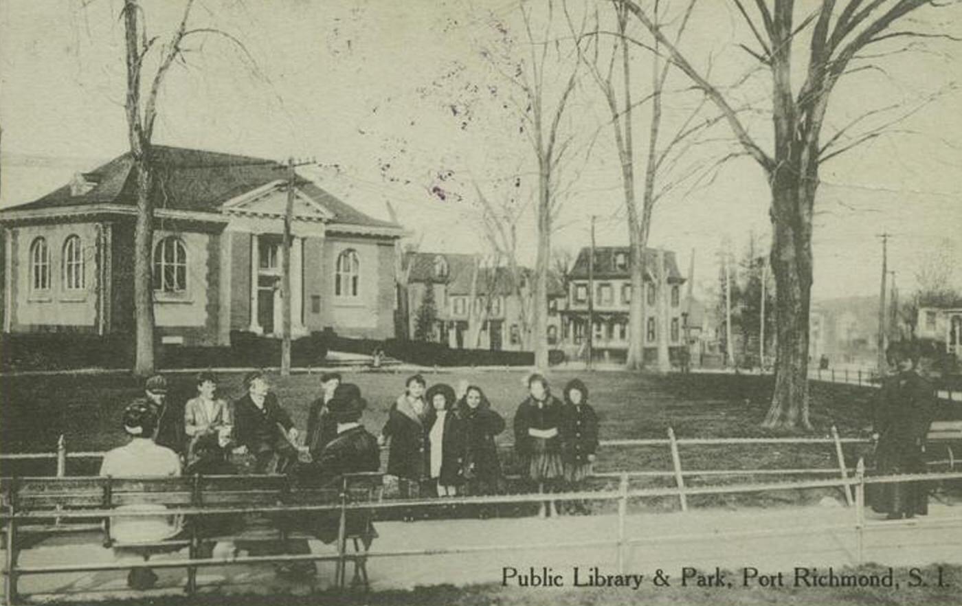 Public Library & Park, Port Richmond, Staten Island, featuring people sitting on park benches in front of the library, 1900s.