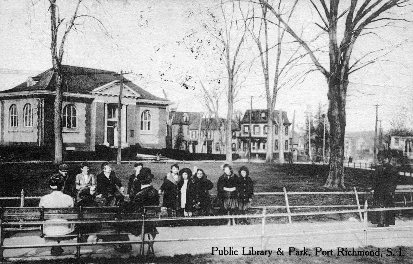 The public library and park in Port Richmond, with people sitting on benches, 1900.