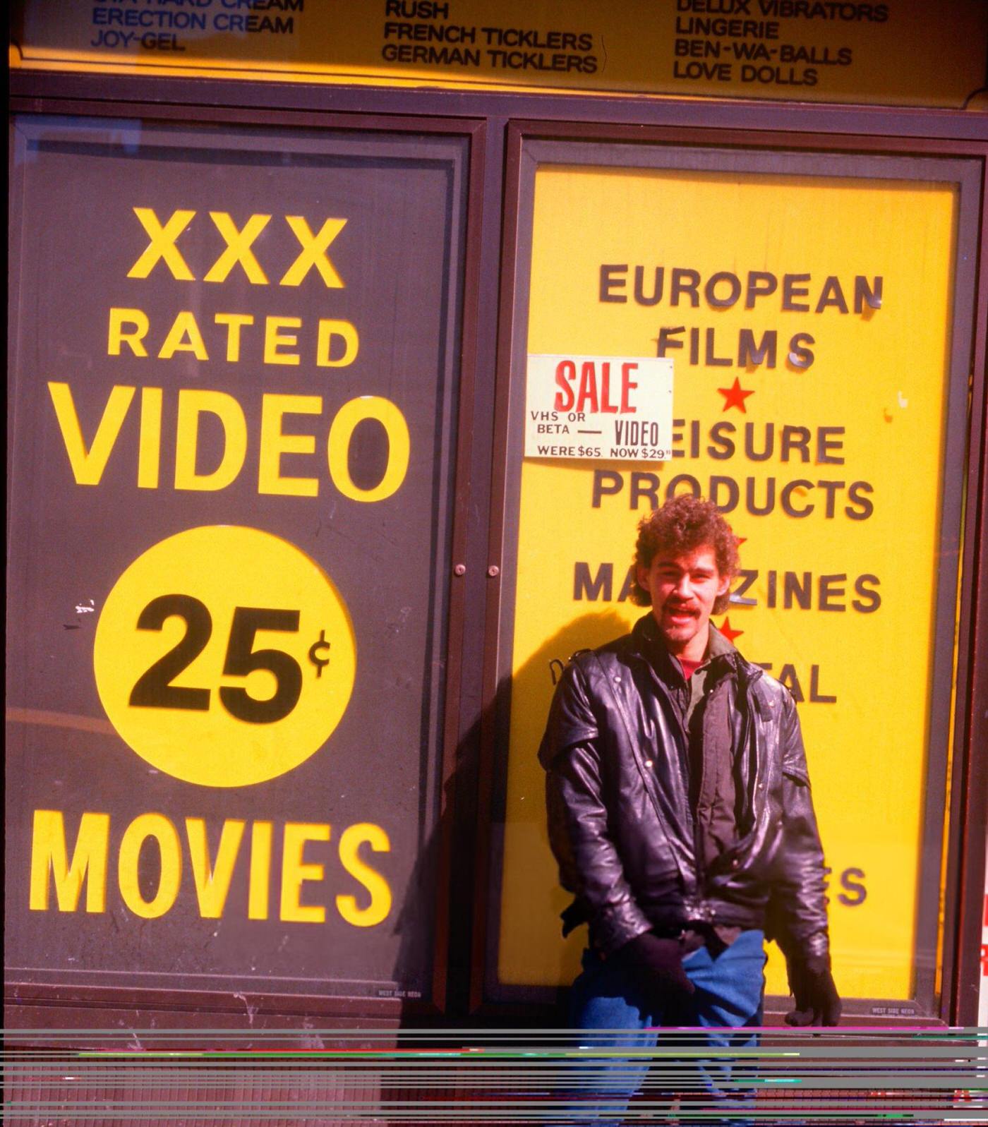 Man in front of an adult movie theatre, 42nd Street and Broadway .