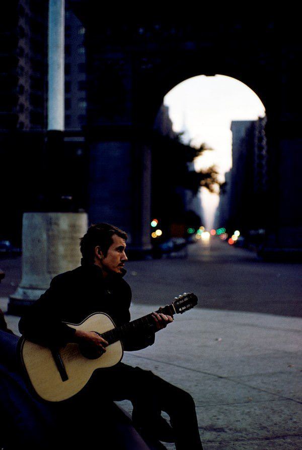 A man plays guitar at dusk in Washington Square Park, 1959.