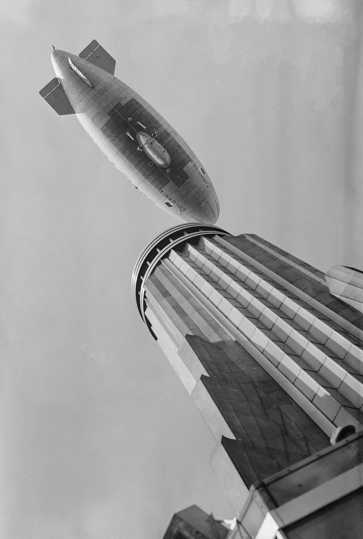 A blimp flying over the Empire State Building, 1931.
