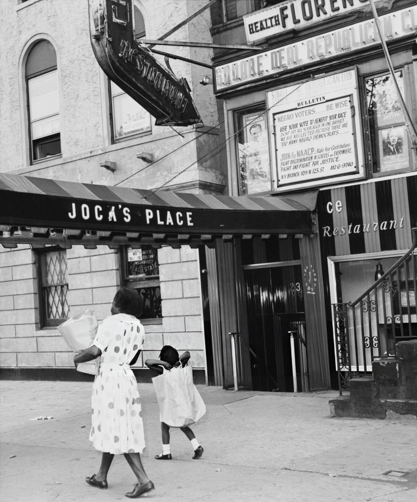 Woman walking past the entrance to Jock's Place in Harlem, 1947.
