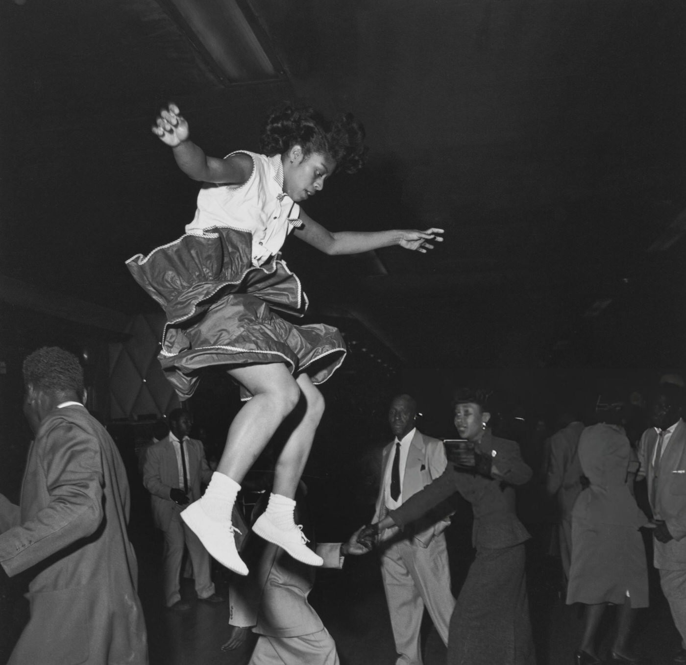 A woman in mid-air during a 'Lindy Hop' dance at the Savoy Ballroom in Harlem, 1947.