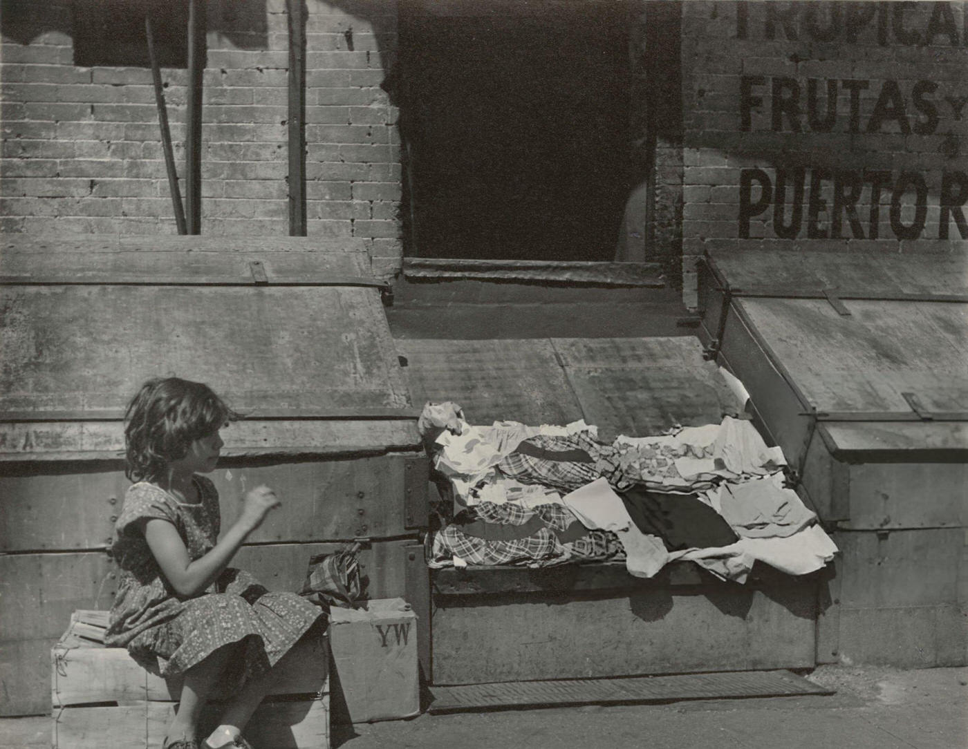 Young girl selling clothes on the street in East Harlem, 1940s.