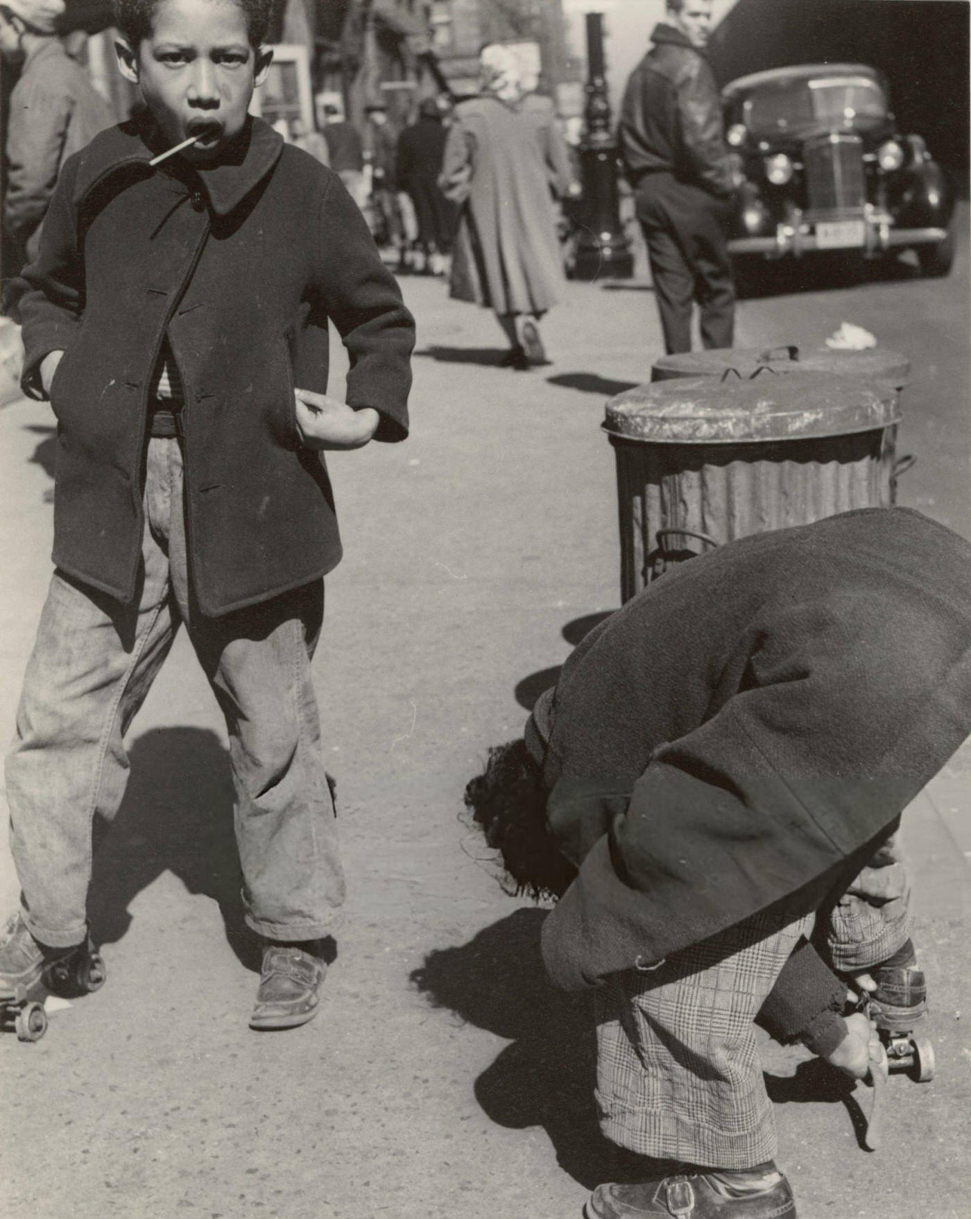 Two boys playing with roller skates on 105th Street, East Harlem, 1940s.