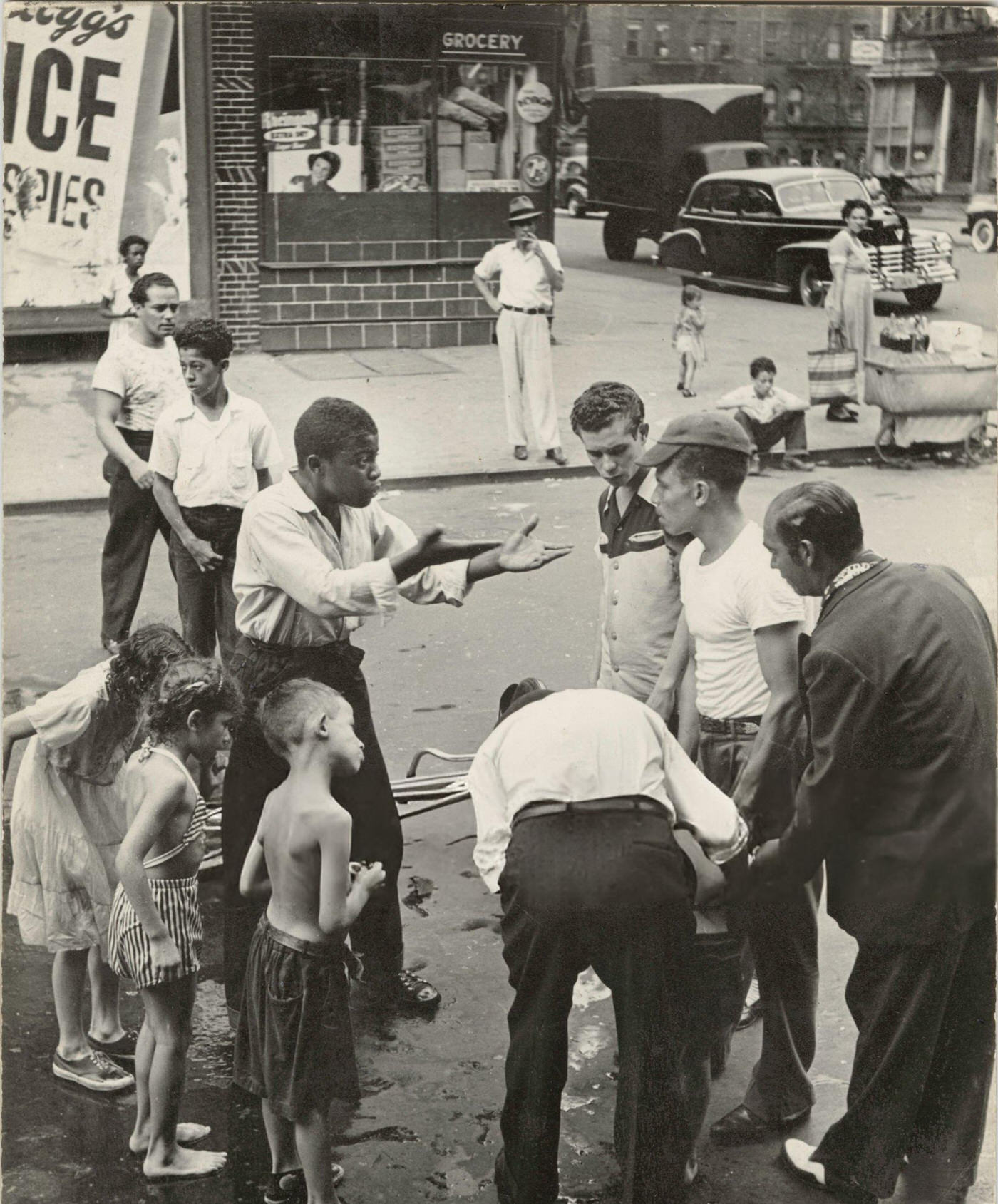Group gathered around an accident victim in East Harlem, 1940s.