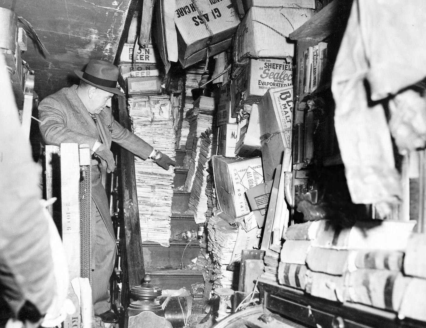 Police inspector looked at the clutter-filled brownstone where the Collyer brothers were found dead, 1947.