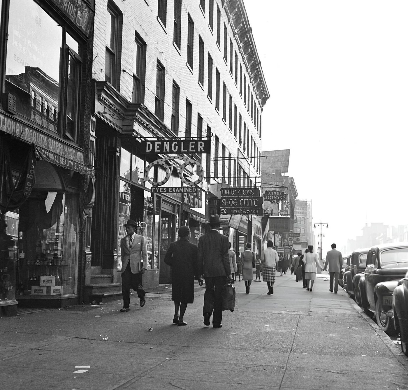 Heavy pedestrian traffic and storefronts along 125th Street in Harlem, 1948.