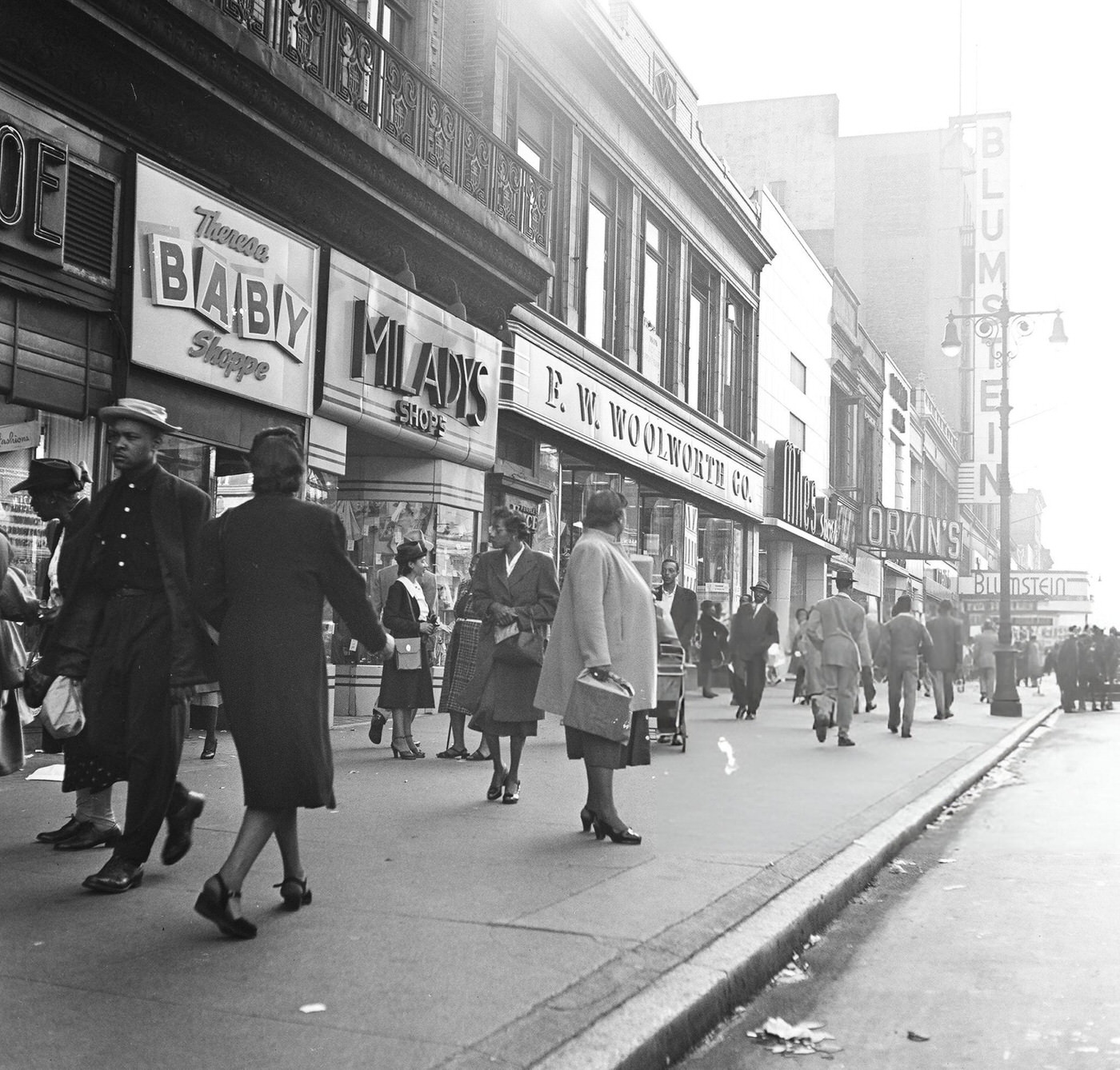 Heavy pedestrian traffic and storefronts along 125th Street in Harlem, 1948.