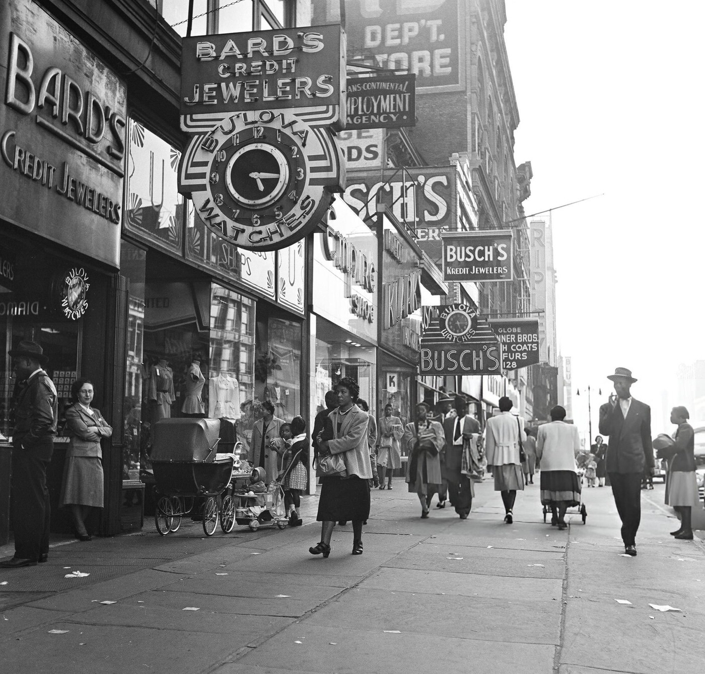 Heavy pedestrian traffic and storefronts along 125th Street in Harlem, 1948.