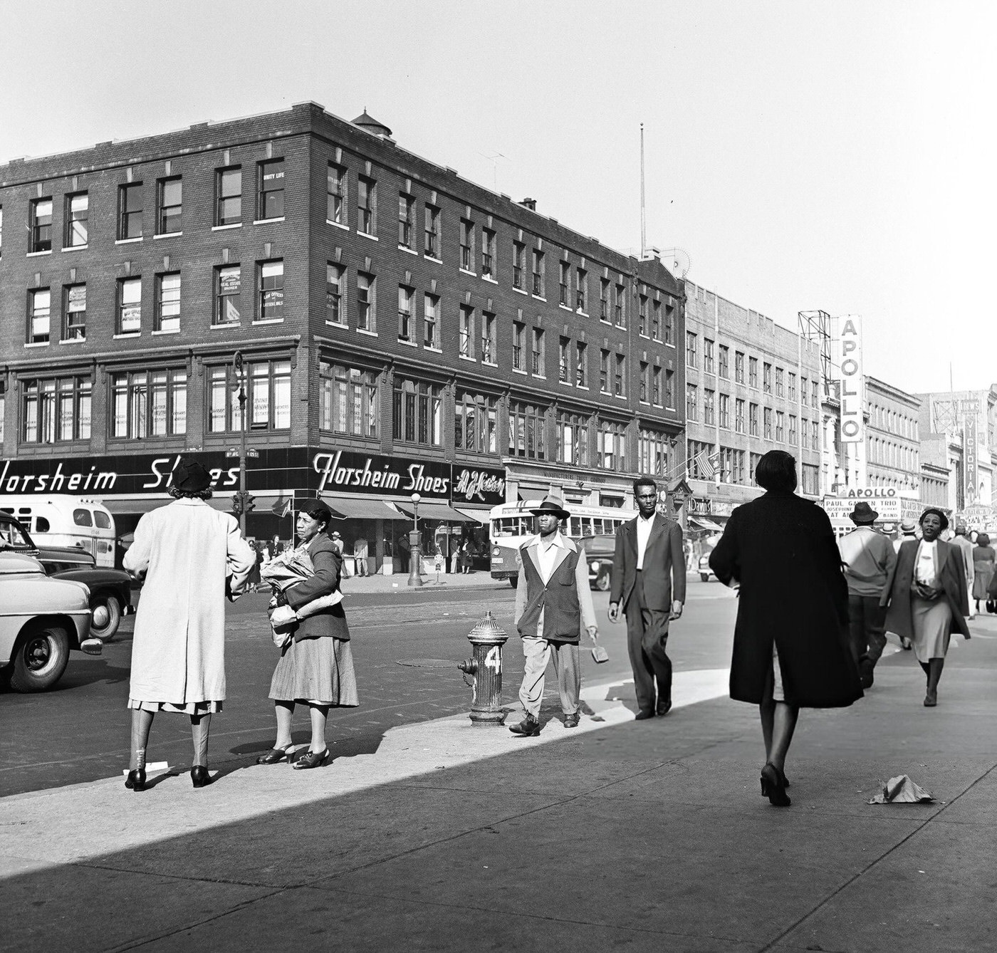 Heavy pedestrian traffic and storefronts along 125th Street in Harlem, 1948.
