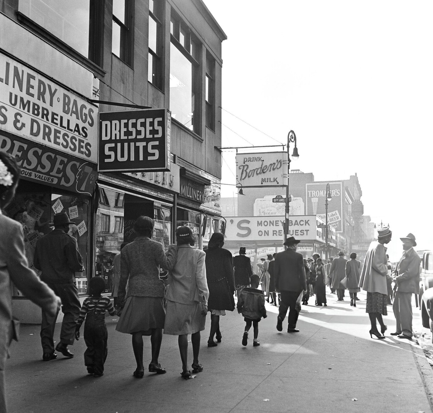 Pedestrian and vehicular traffic at the corner of 125th Street and 7th Avenue in Harlem, 1948.