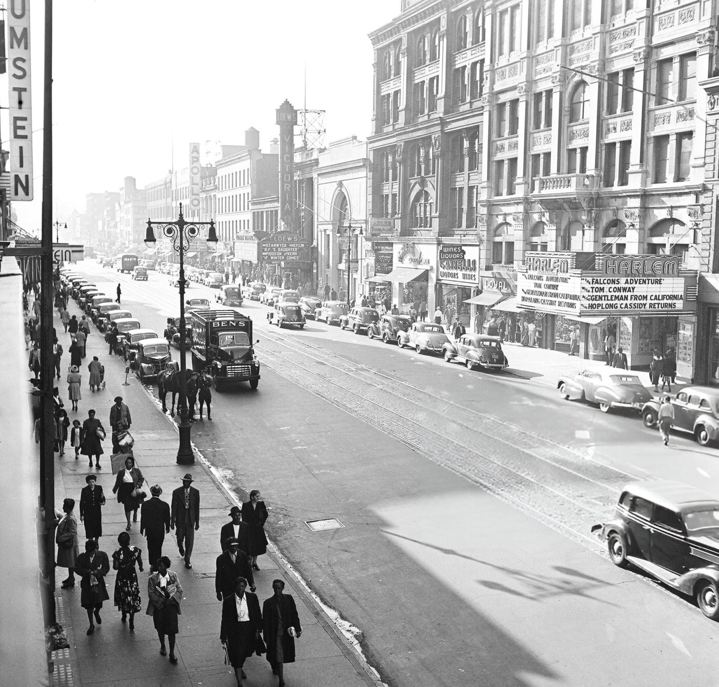 Pedestrian and vehicular traffic at the corner of 125th Street and 7th Avenue in Harlem, 1948.