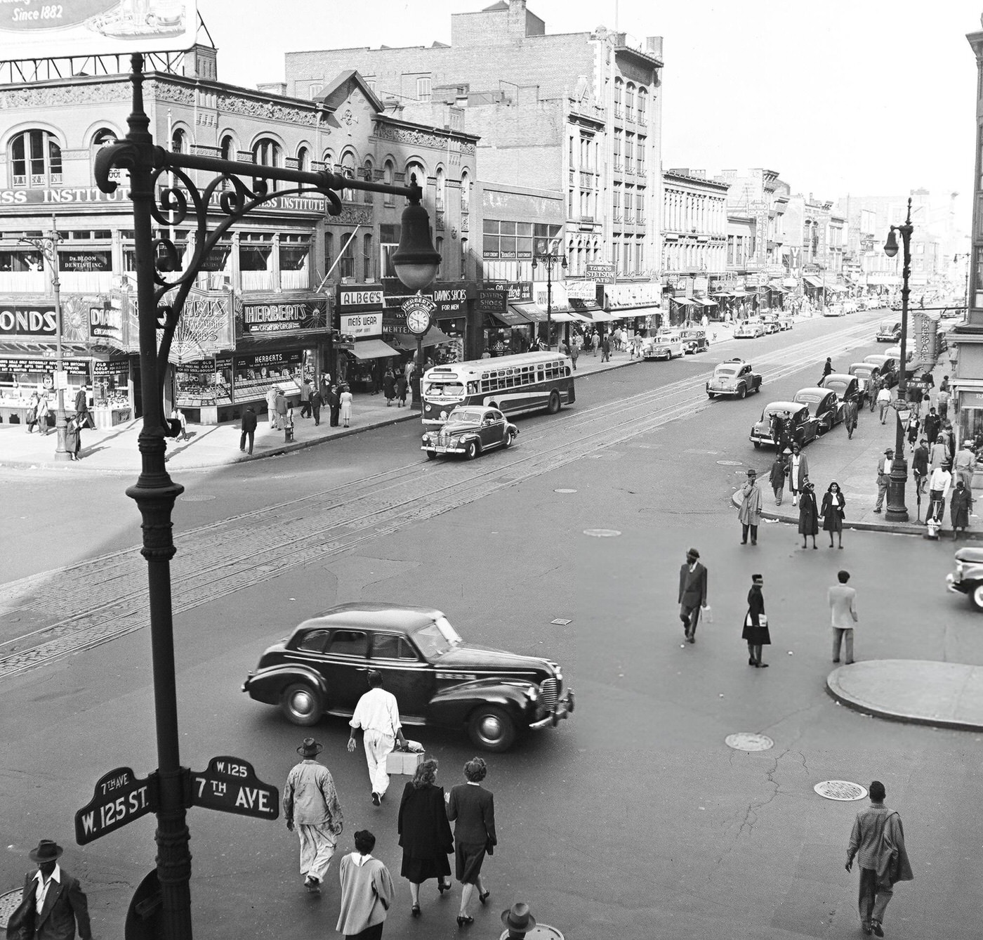 Pedestrian and vehicular traffic at the corner of 125th Street and 7th Avenue in Harlem, 1948.