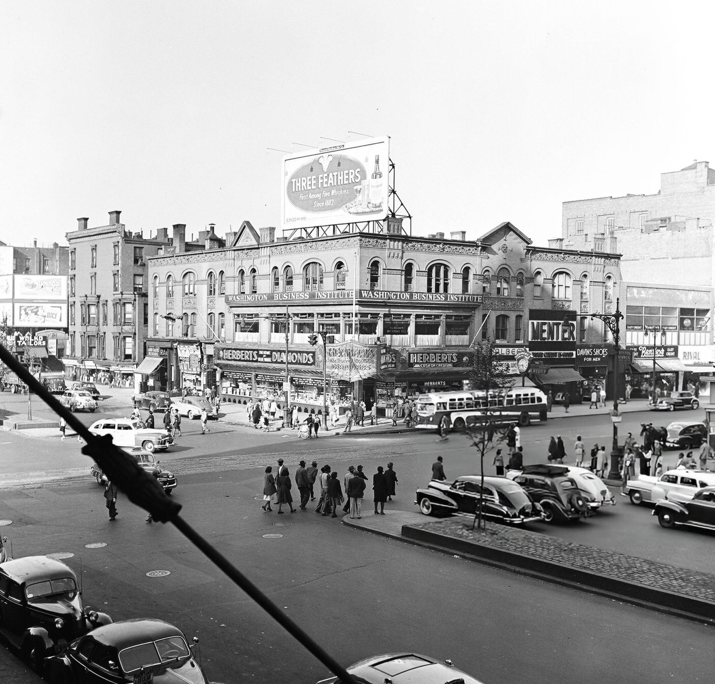 Pedestrian and vehicular traffic at the corner of 125th Street and 7th Avenue in Harlem, 1948.