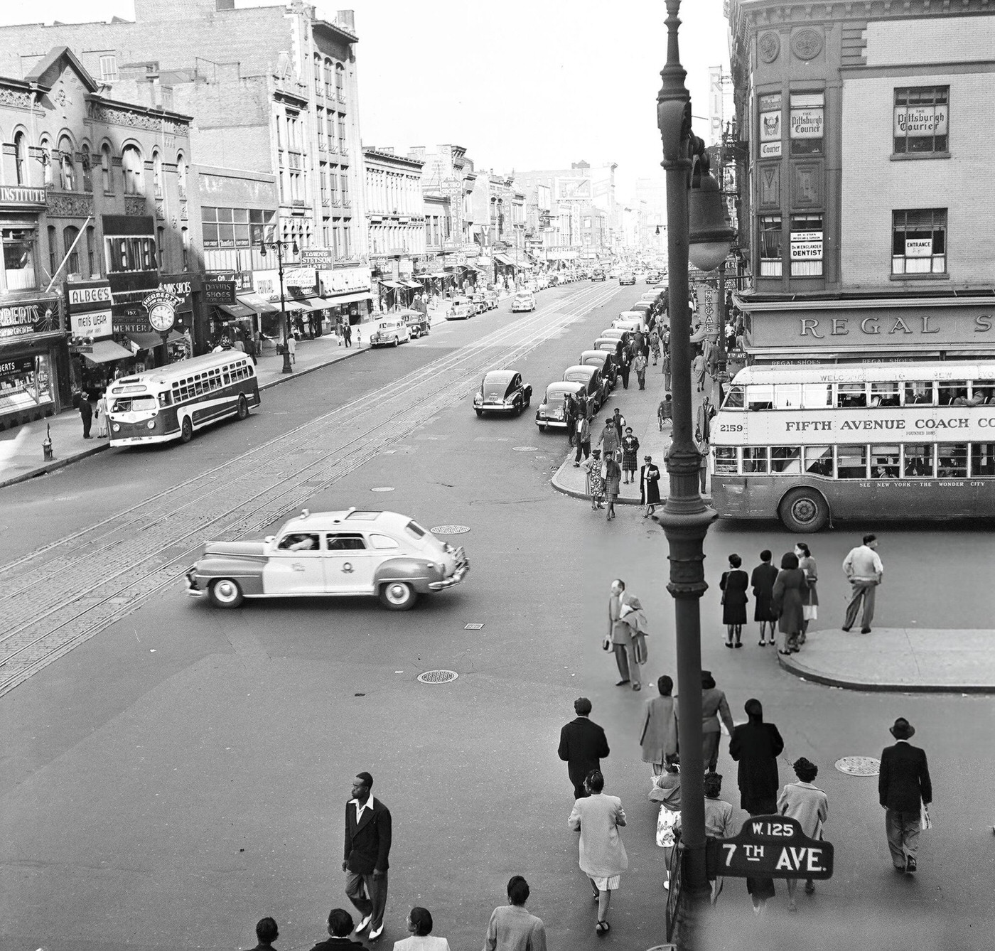Pedestrian and vehicular traffic at the corner of 125th Street and 7th Avenue in Harlem, 1948.