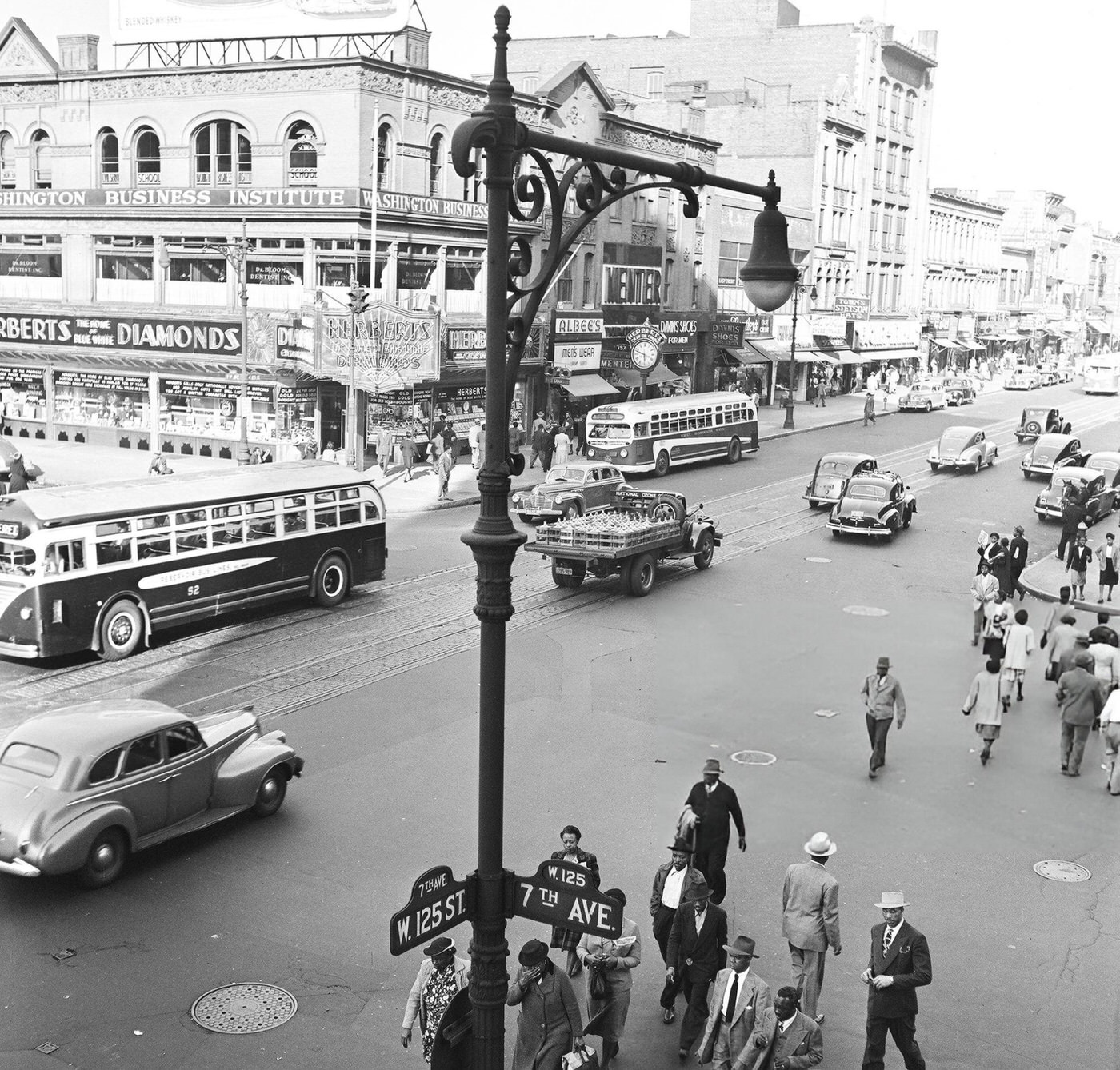 Pedestrian and vehicular traffic at the corner of 125th Street and 7th Avenue in Harlem, 1948.
