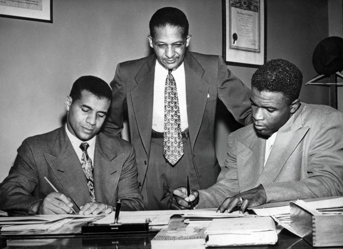 Roy Campanella and Jackie Robinson of the Brooklyn Dodgers sign on to the staff of the Harlem Branch of the YMCA, 1948.
