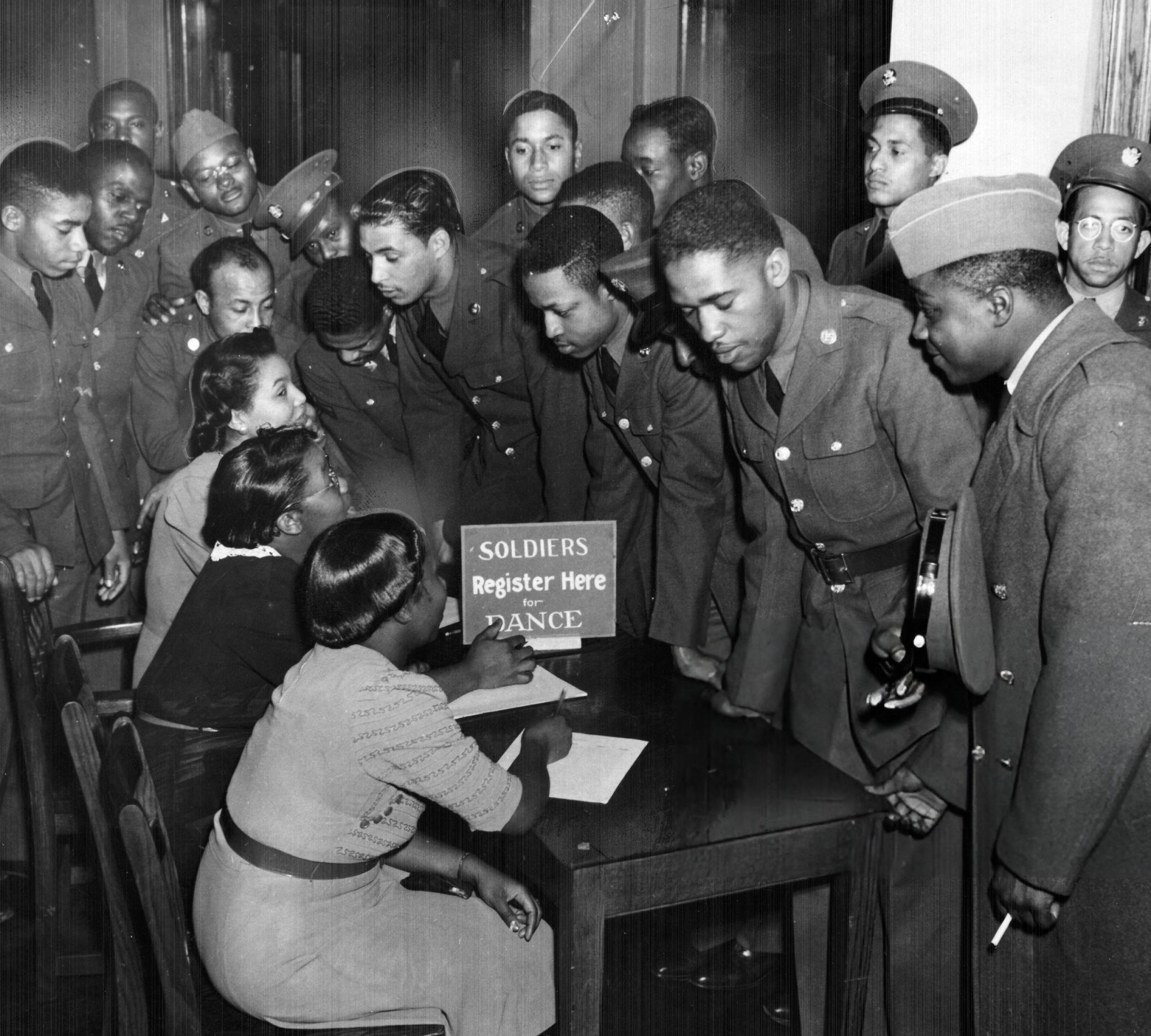 USO hostesses signing up soldiers for a dance, Japan, 1942.