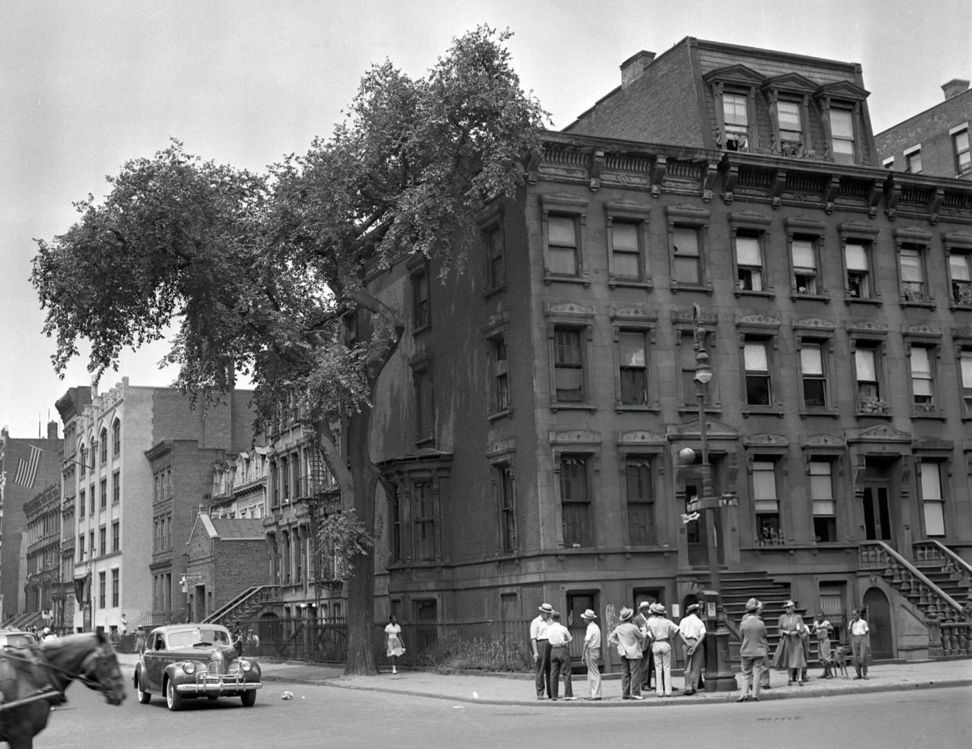 Curious bystanders ogle the "hermit house" of the Collyer brothers, Harlem, 1940s.