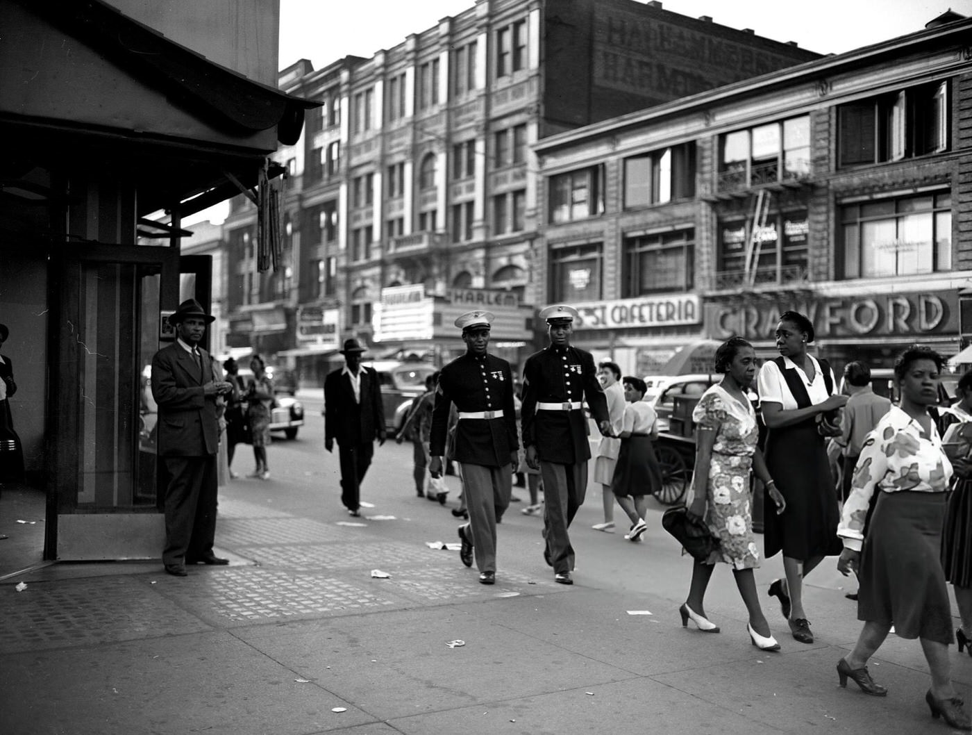 Soldiers moving with the crowd on the streets of Harlem, 1943.