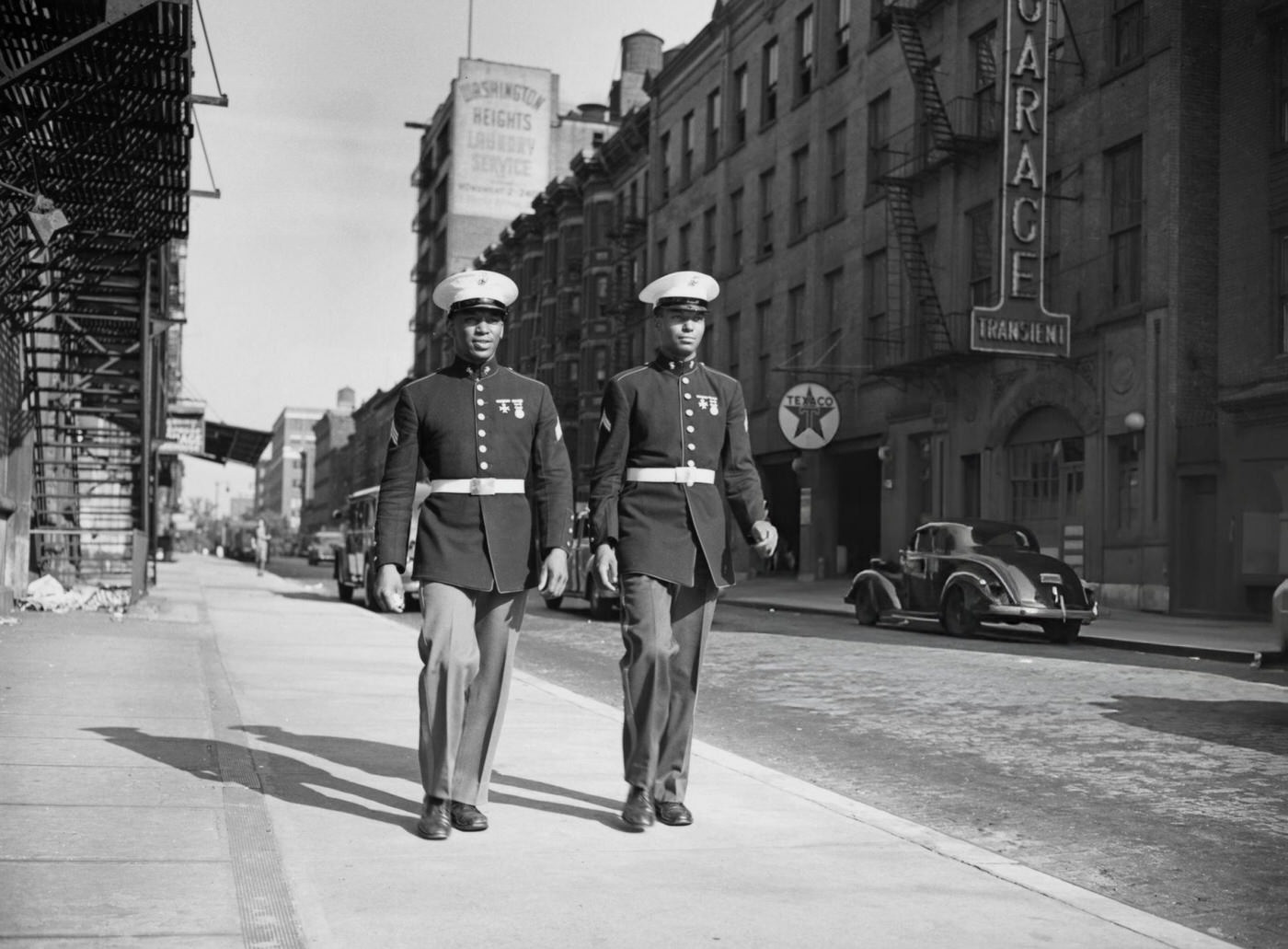Two Marines walk down a street in Harlem, 1943.