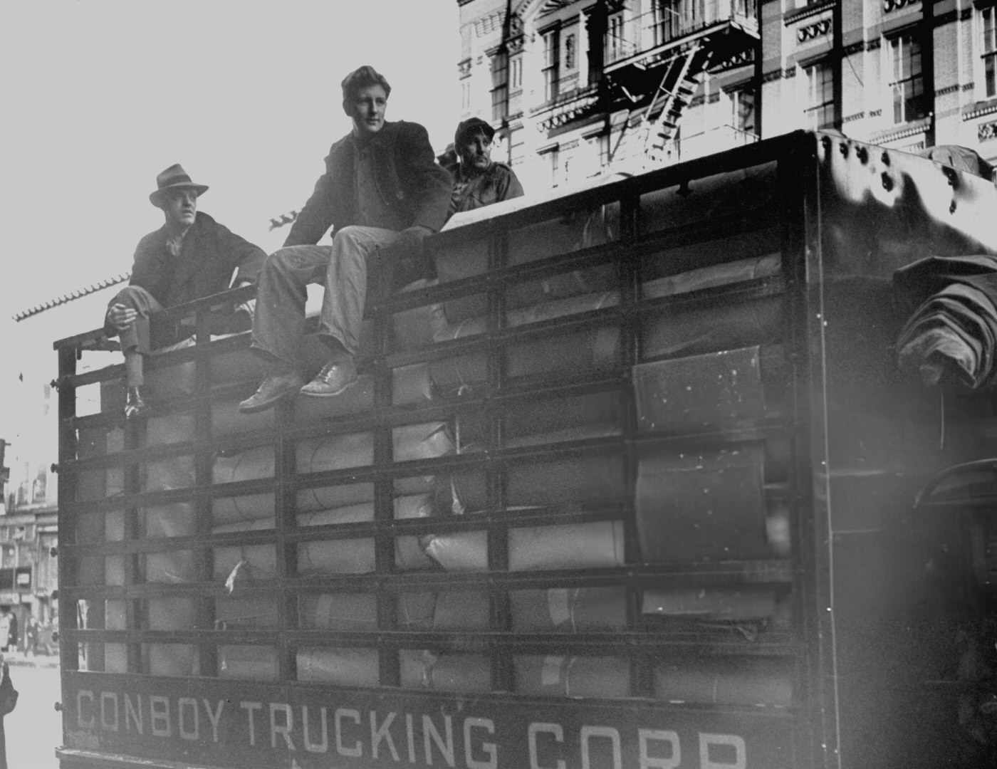 Armed guards riding on a truck carrying woolens through East Harlem, 1940s.