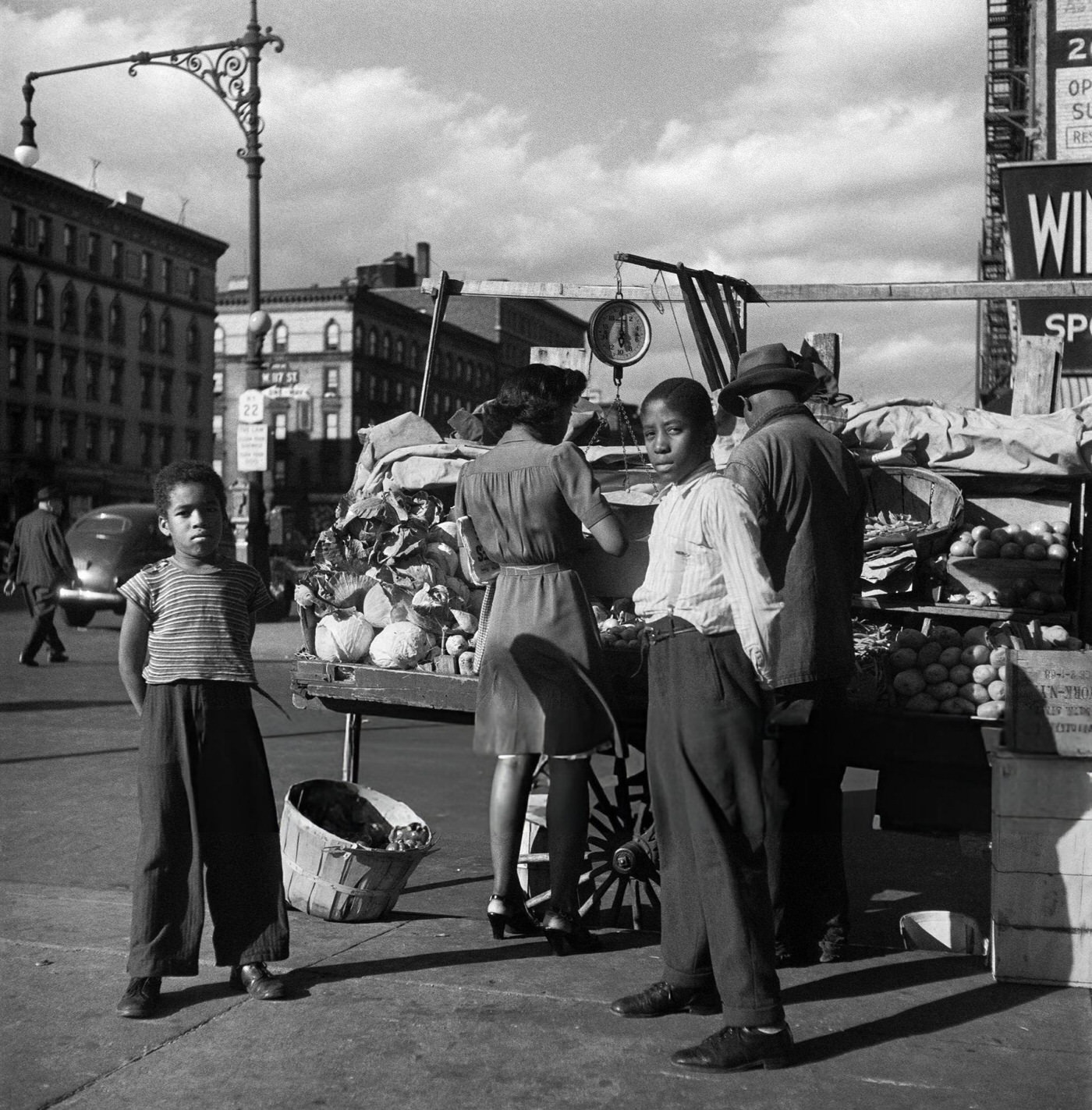 People buy fruits and vegetables from a street vendor in Harlem, Manhattan, 1946.