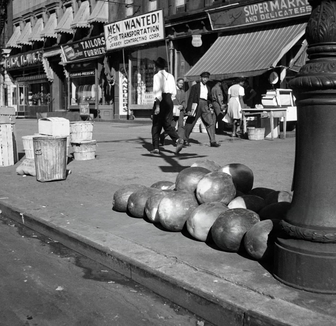 People pass by watermelons in front of a supermarket in Harlem, Manhattan, 1946.