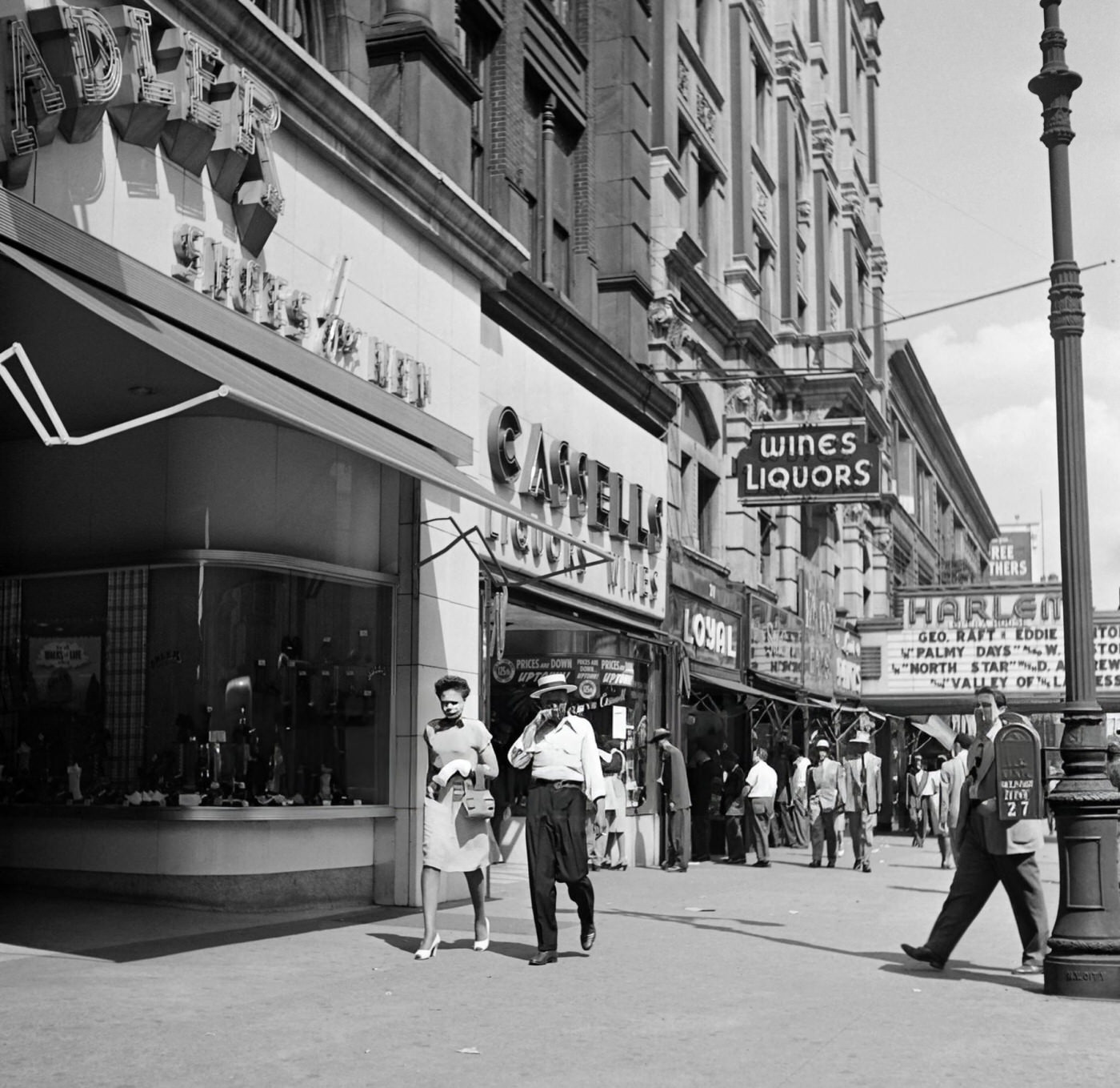 People walk on the sidewalk in Harlem, Manhattan, 1946.