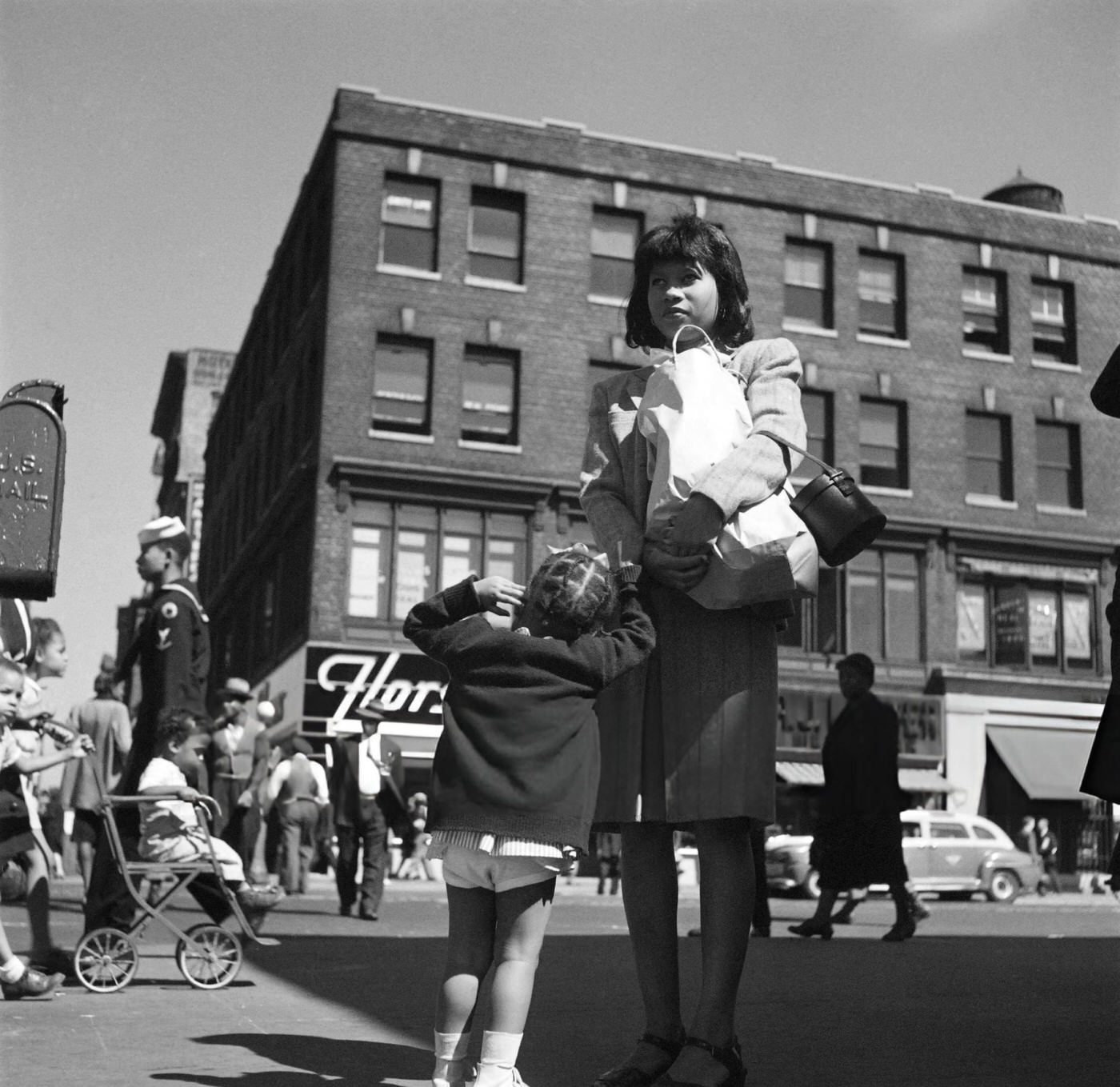 An African American woman and her little girl wait for a bus in Harlem, Manhattan, 1946.