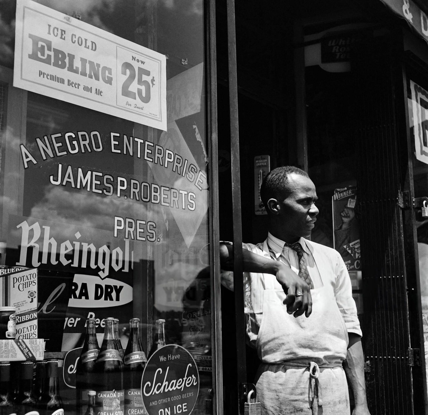 An African American seller waits at the entrance of his liquor store in Harlem, Manhattan, 1946.