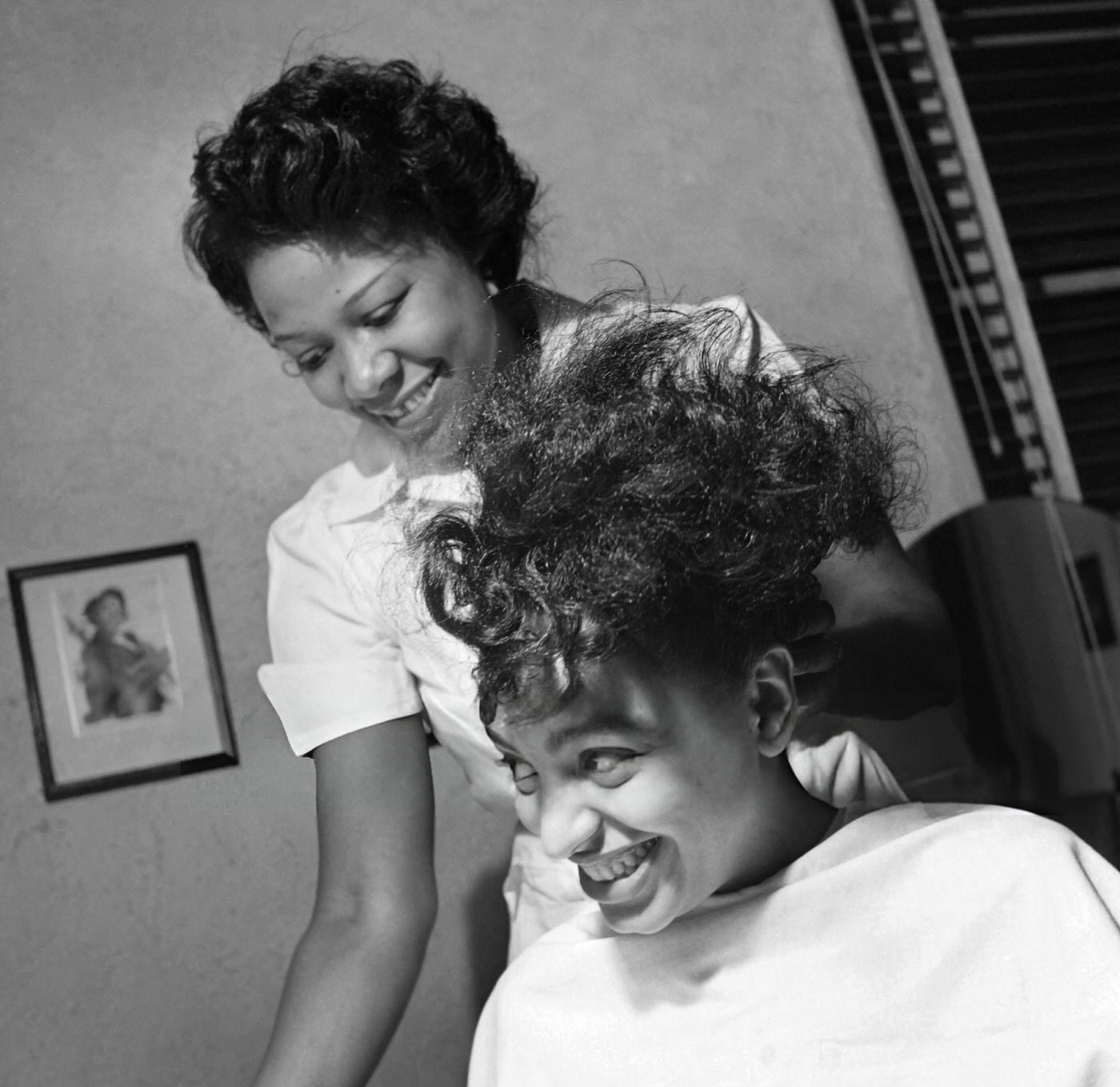 A hairdresser does her clients' hair in a hairdressing salon in Harlem, 1946.