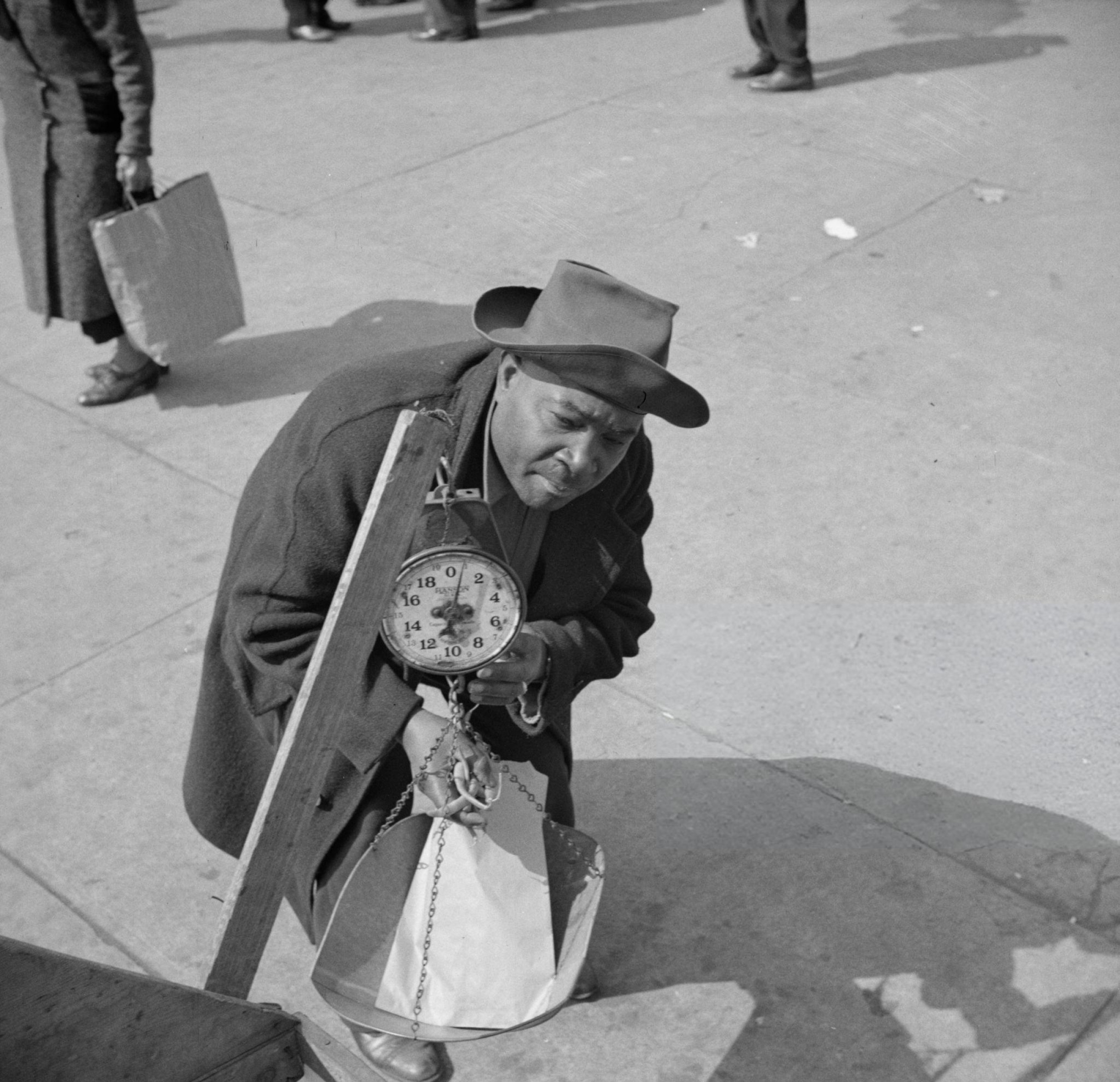 Street peddler in Harlem weighing string beans.