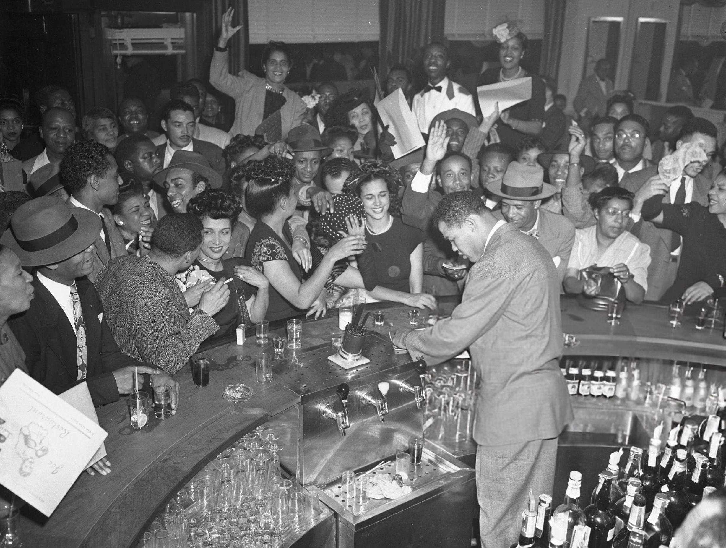 Joe Louis signing autographs at his restaurant in Harlem, 1946.