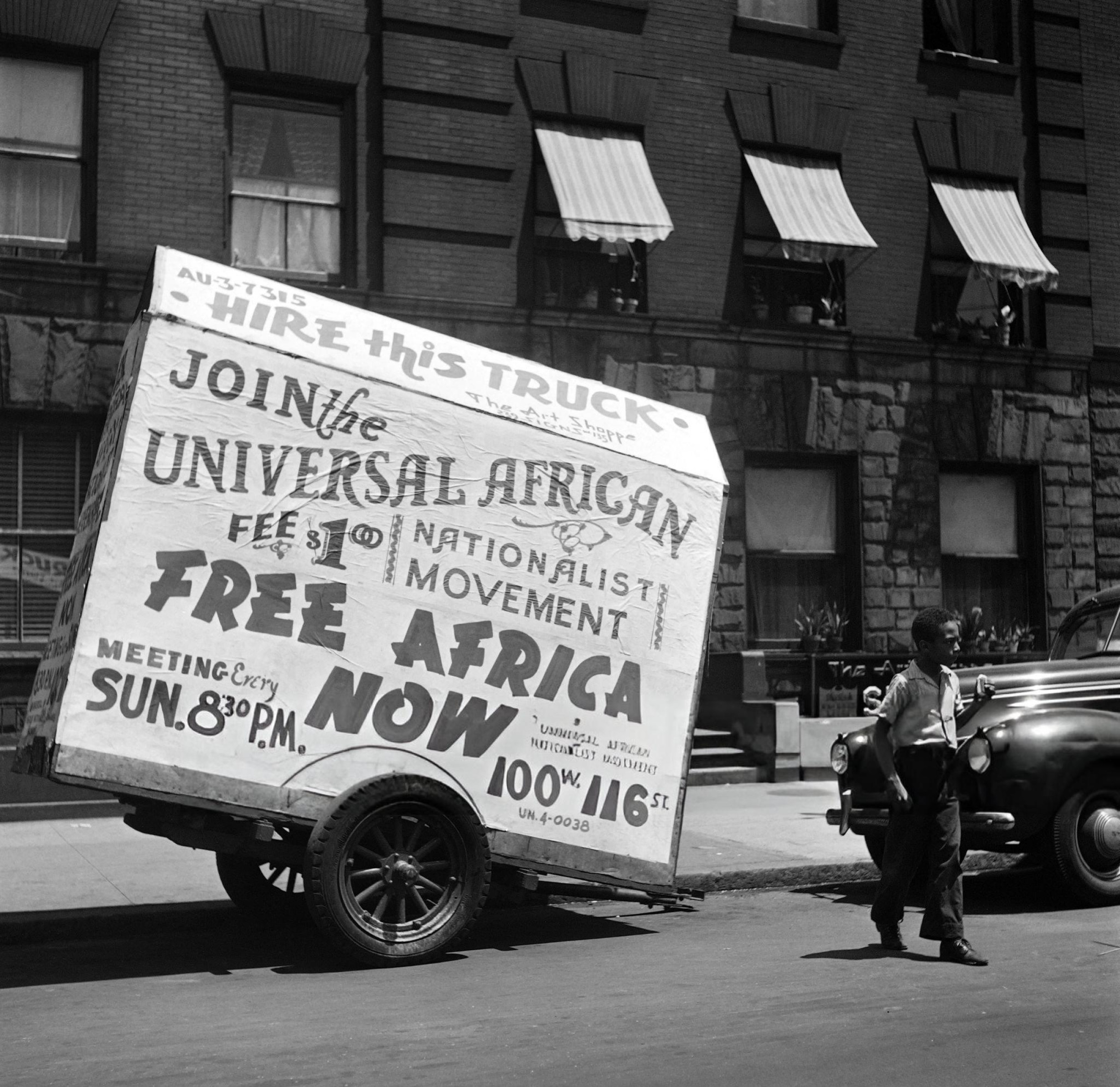 A trailer truck covered with a poster saying "Free Africa now" parked in Harlem, Manhattan, 1946.