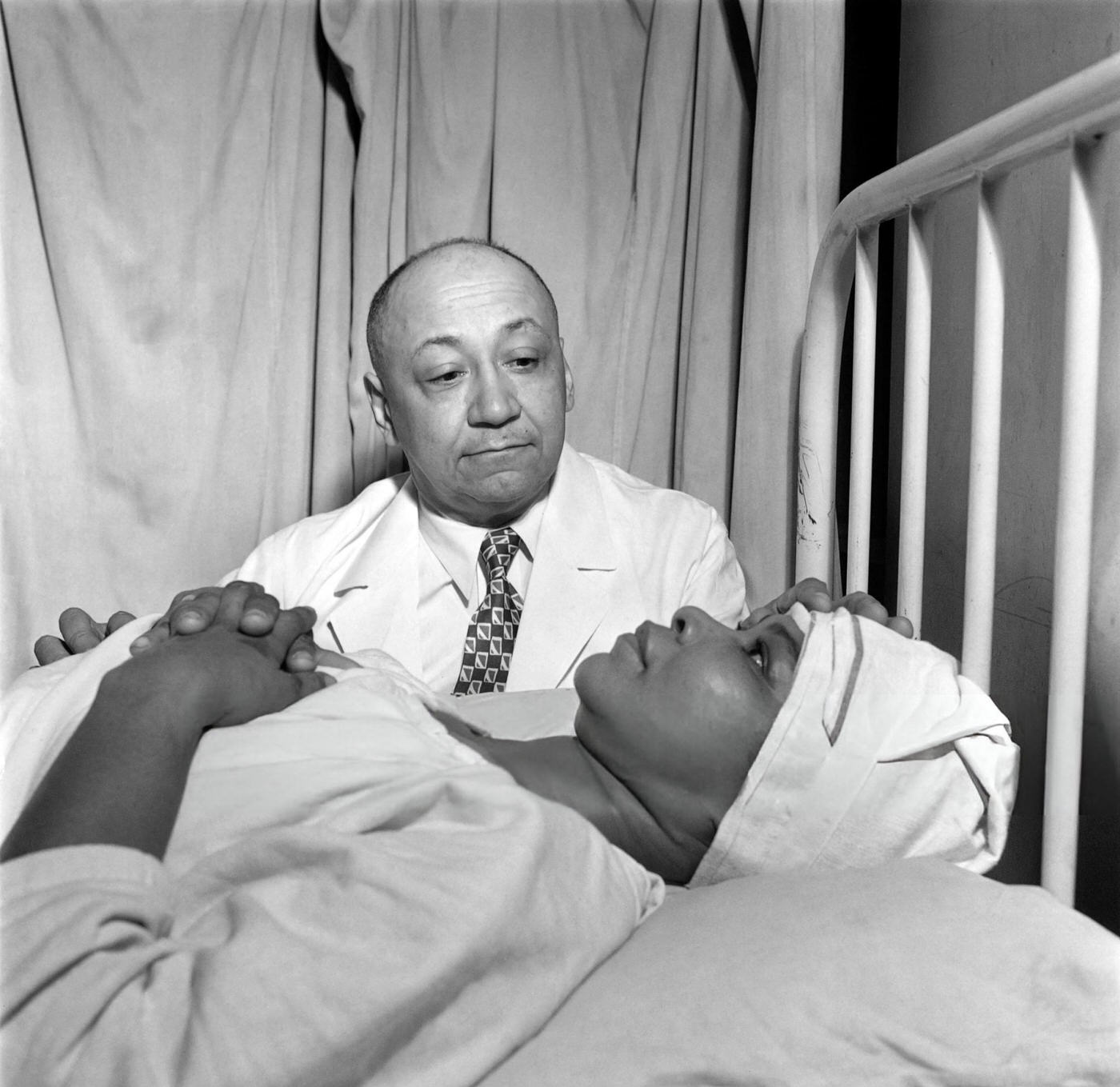 A doctor takes care of an African American woman in a hospital in Harlem, Manhattan, 1946.