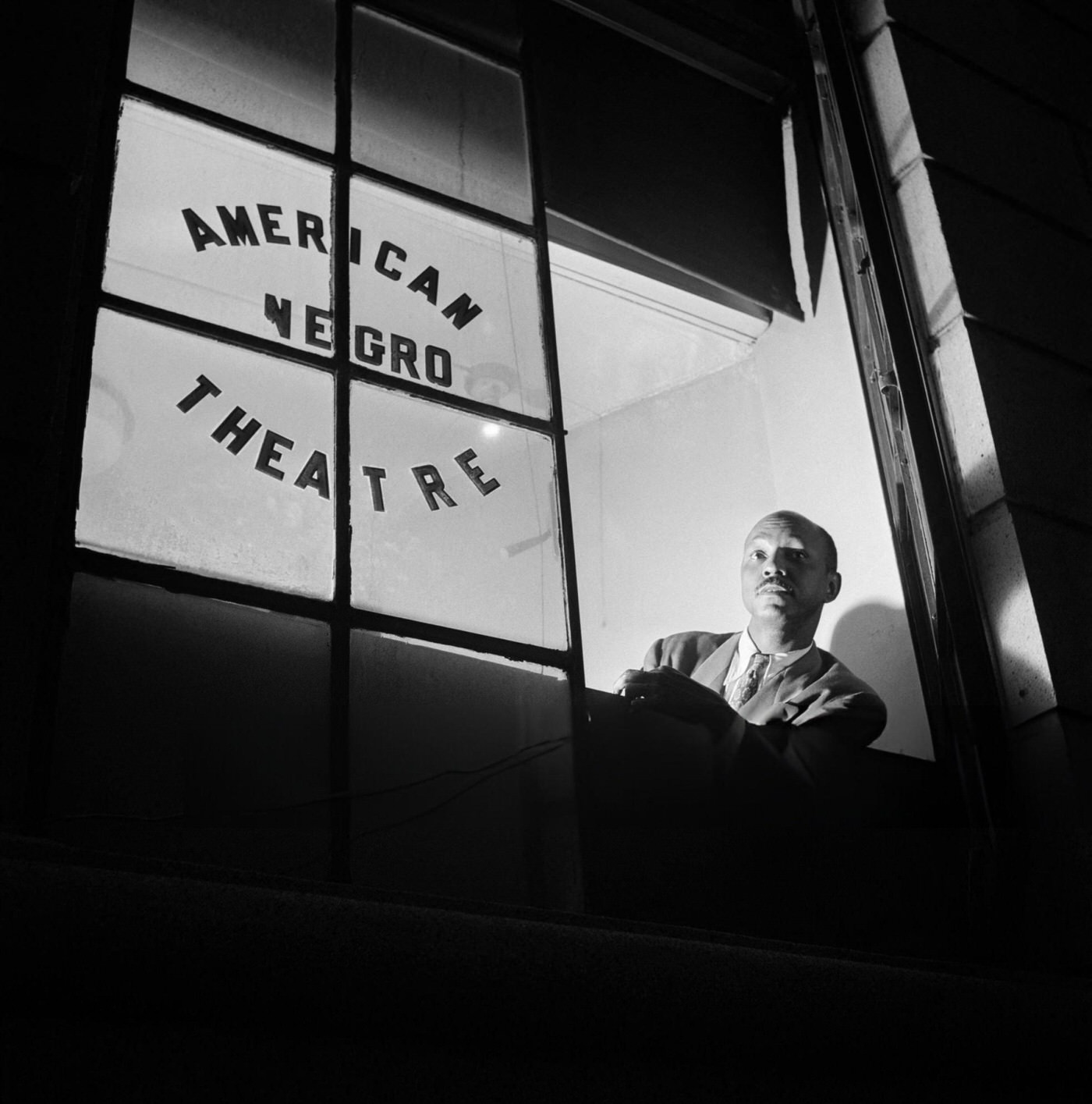 A man looks out the window of the "American Negro Theatre" in Harlem, 1946.