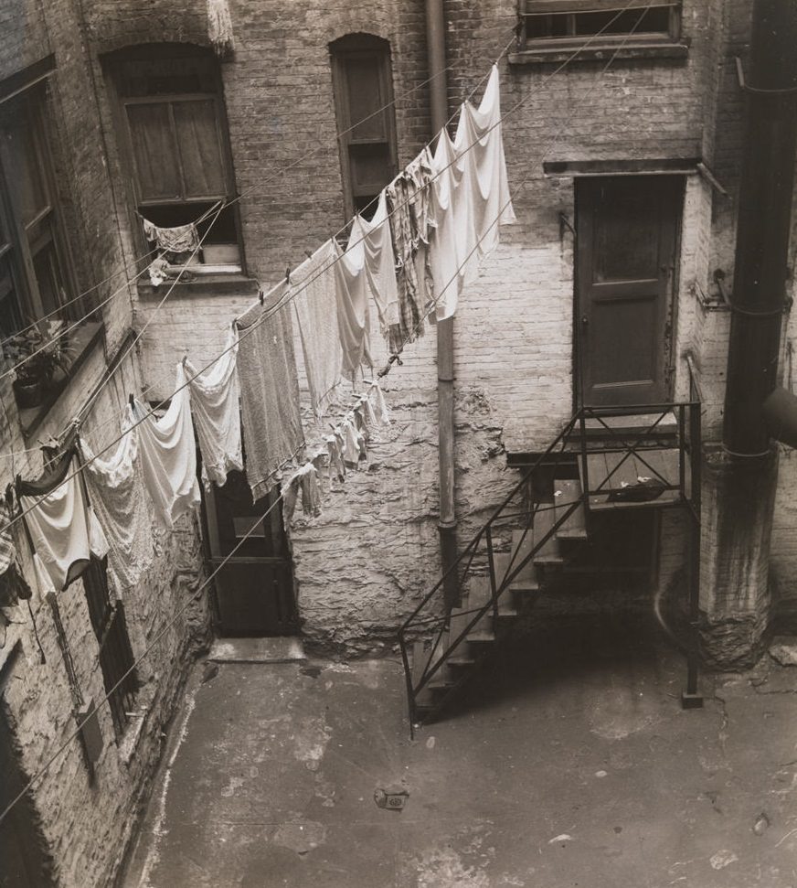 Clothesline strung between windows in brick courtyard, 1392 Madison Ave, 1933.
