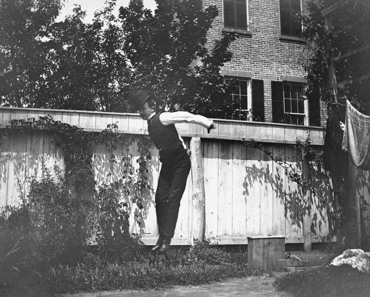 J.M. Cornell jumps in the backyard at 314 Livingston Street, 1886.