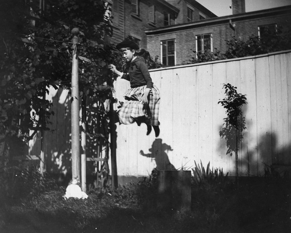Zelma Levison jumps in the backyard of her home at 314 Livingston Street, 1886.